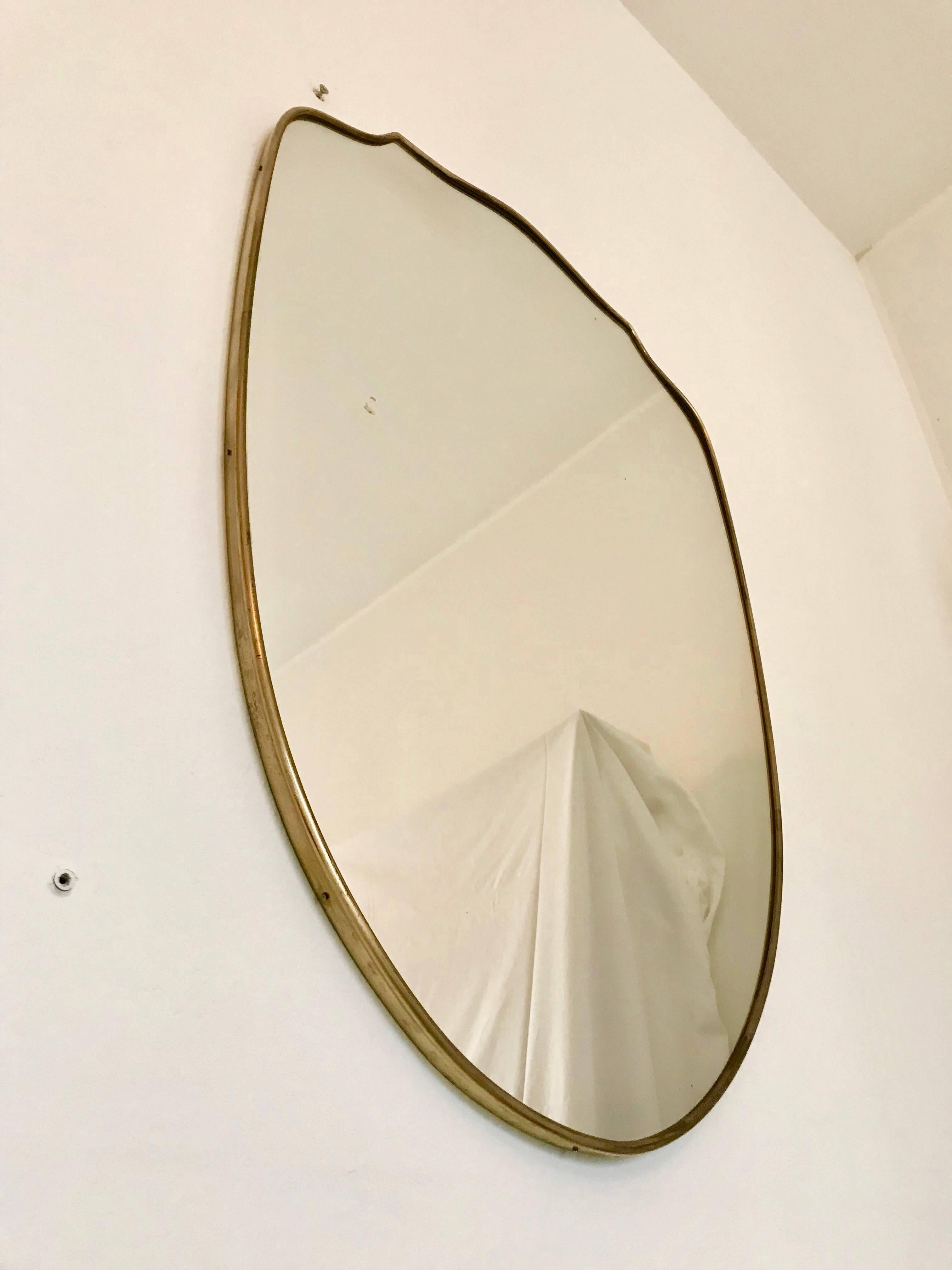 Authentic Italian Brass Mirror from the Mid Century period, original condition in the style of Gio Ponti. The mirror presents some signs which is completely normal due to age and a direct testimony of its intact authenticity. Approx size 78h x 56 cm