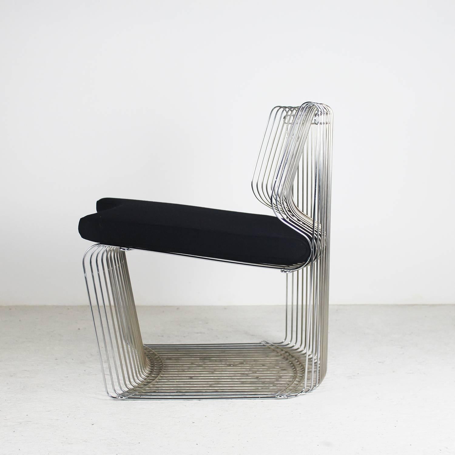 A 1970s pair of lounge chairs by the famous designer Verner Panton in chromed metal and a cushion in black fabric.