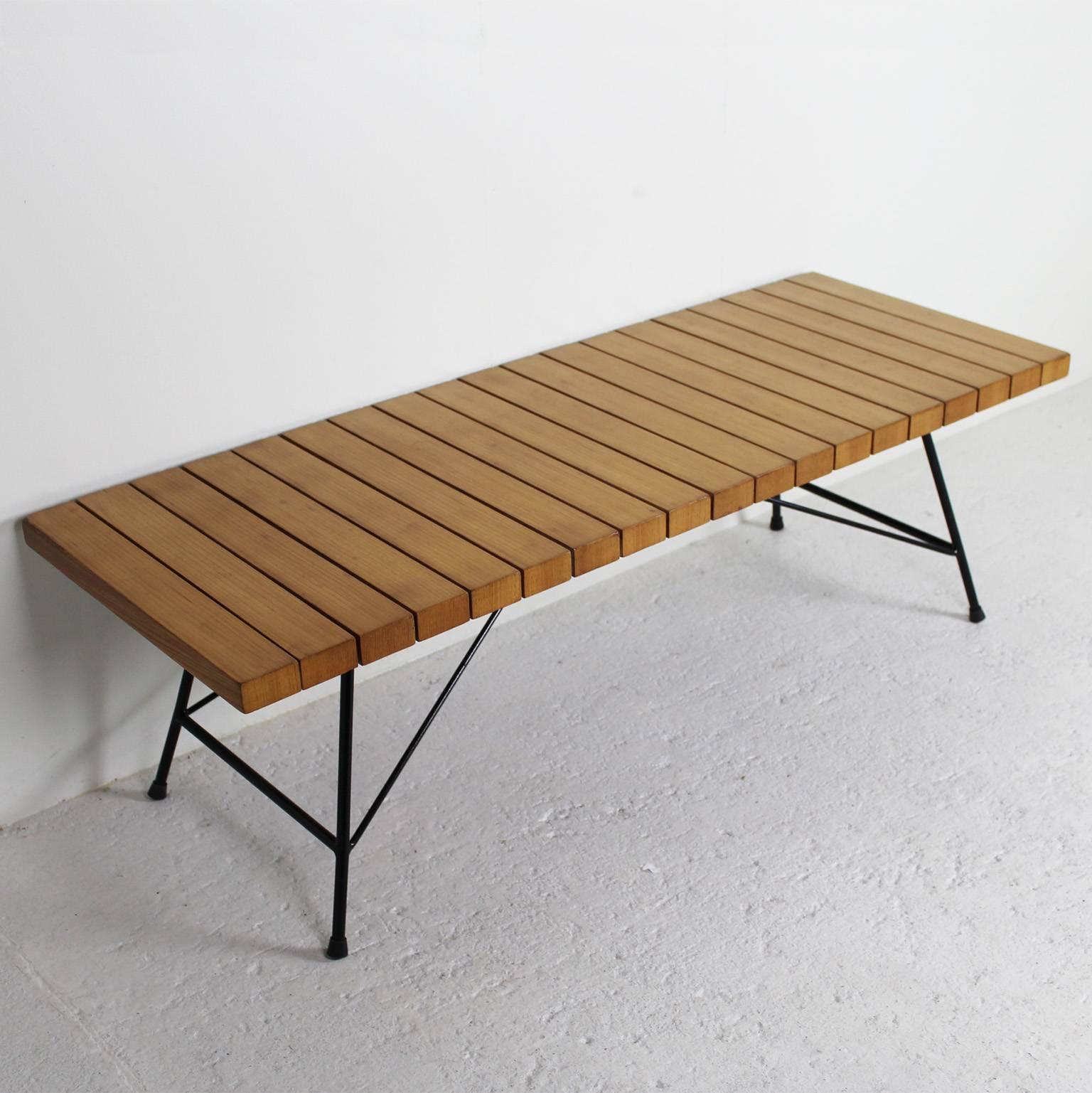 A bench or coffee table by the French designer Alain Richard in the 1950s. The manufacturer's label is underneath the frame in tubular black lacquered metal. The wooden slats are in cherrywood.