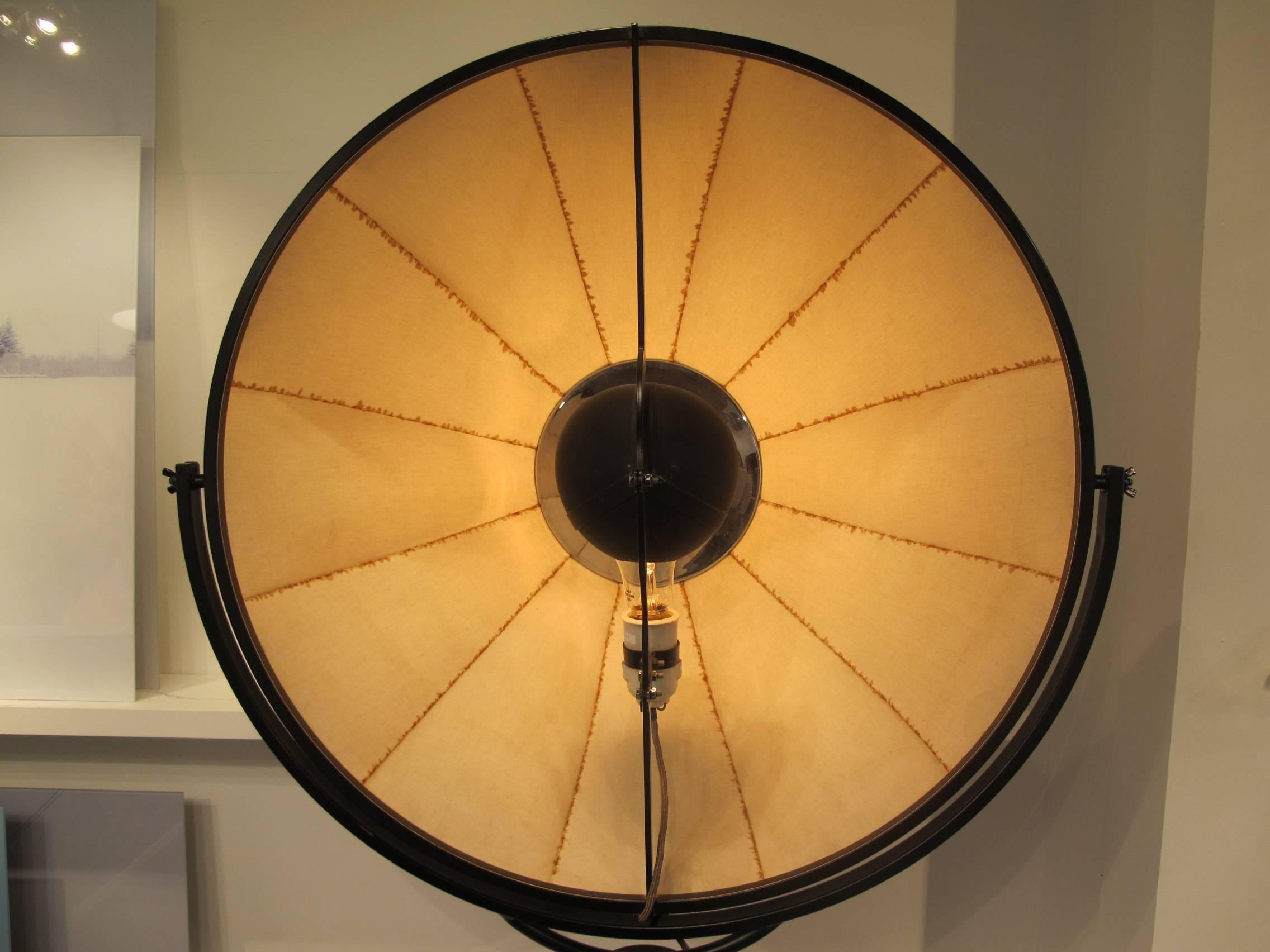 A vintage photographer's lamp by Mariano Fortuny, circa 1960.
Features a large Fabric Shade on a movable arm, mounted on a metal Tri-pod bas with adjustable height mechanism.
An early original example of modern Italian Design