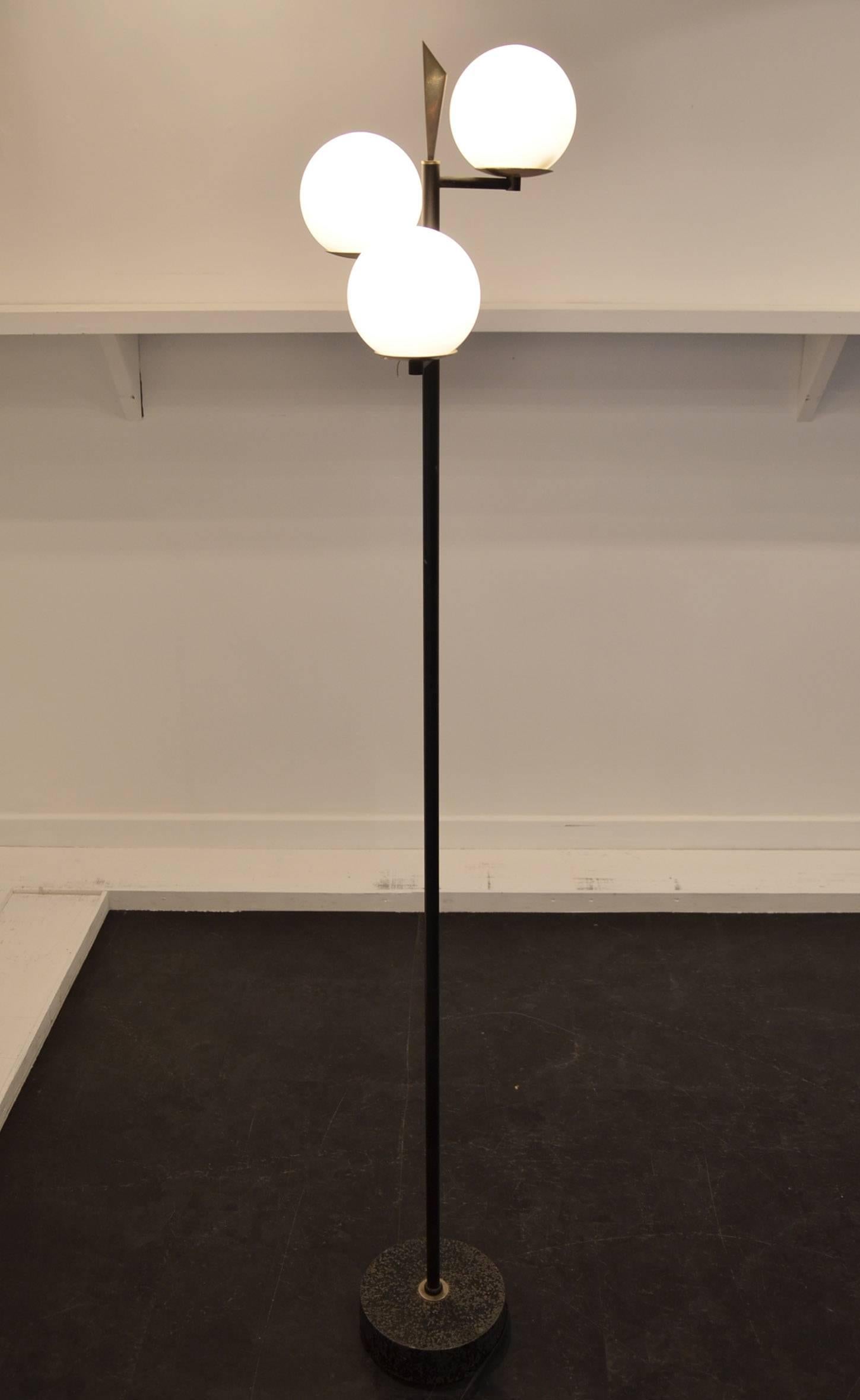 Black lacquered metal and opaline floor lamp consisting of a circular base in black lacquered metal on which is placed a cylindrical lacquered metal trunk supporting three offset opal glass lights. Each glass is set on a circular nickel metal plate.