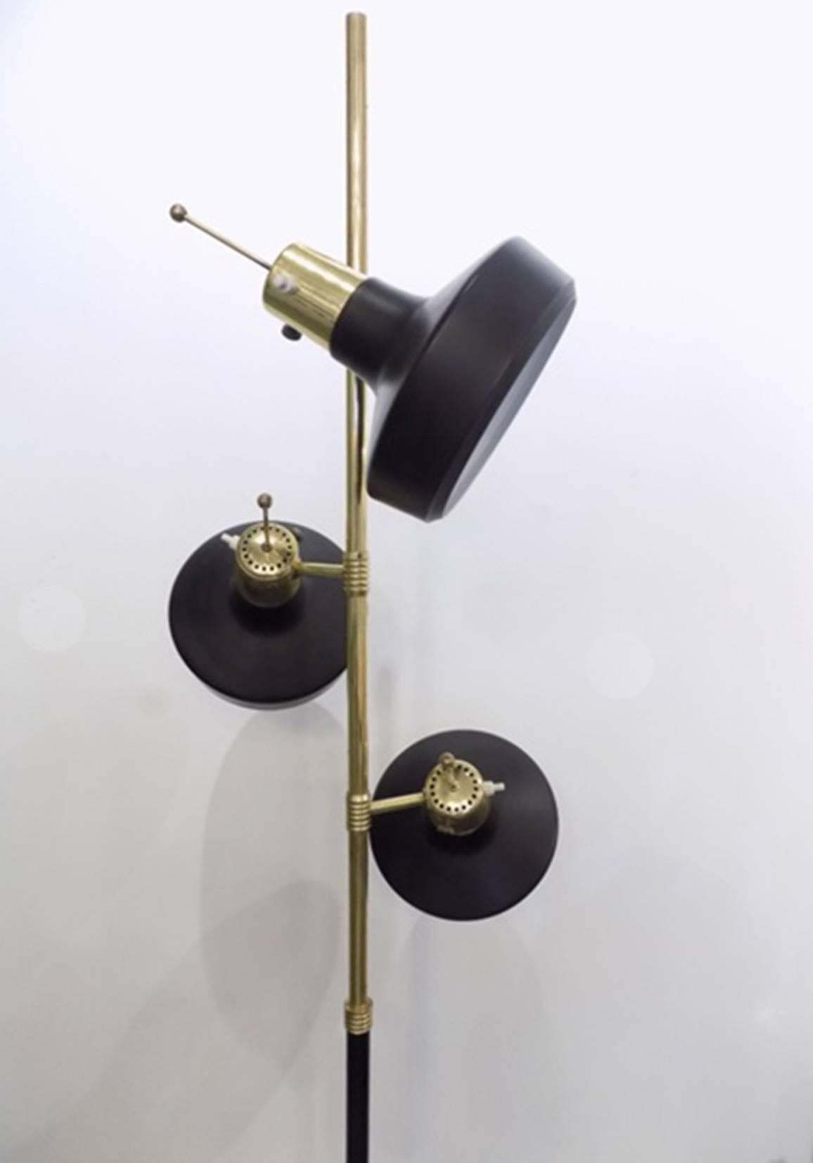 A Monix floor lamp, Paris, circa 1960 
three adjustable Directional light points. 
Brass spindle and black enamel lights with white interiors.
