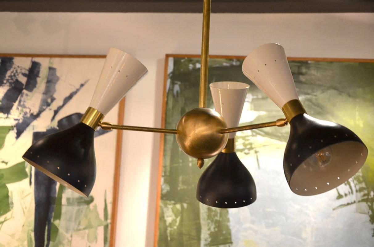 Brass structure and three rotative black and white lacquered diabolo lampshades.
