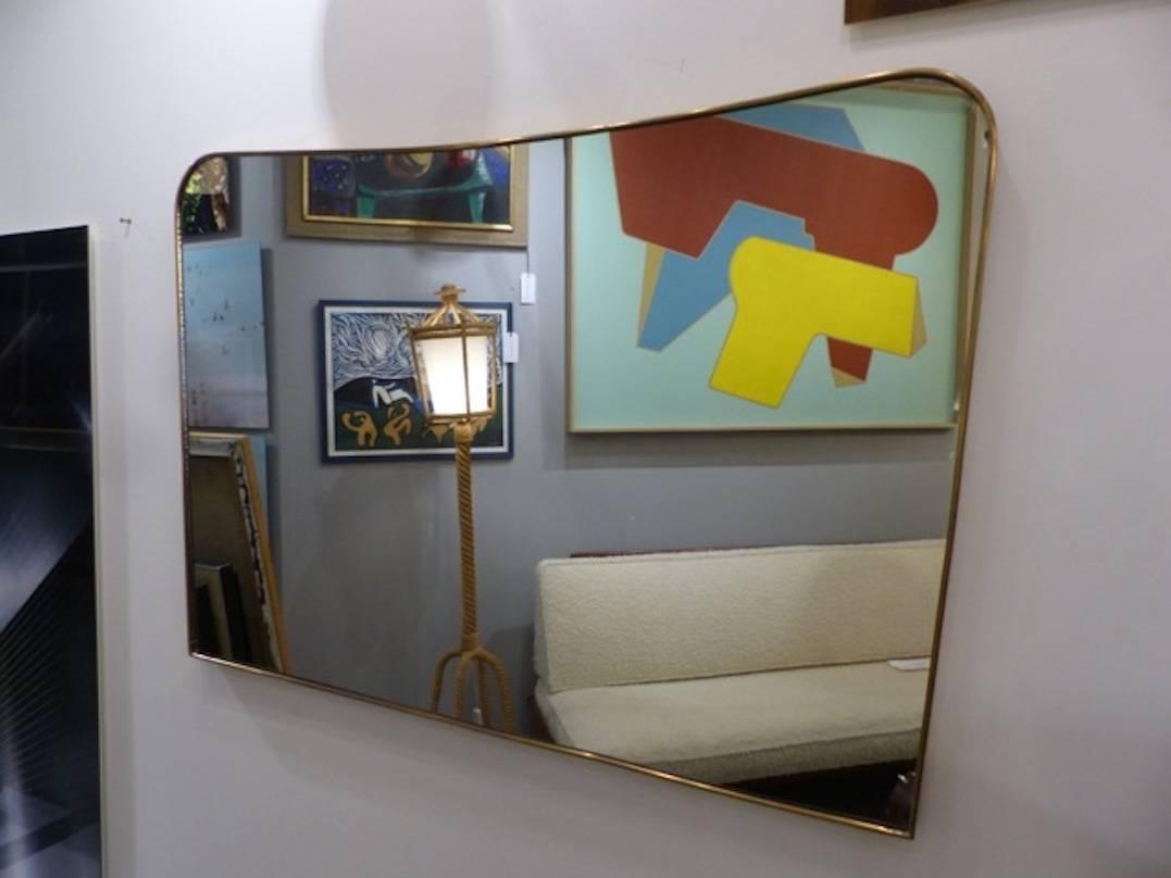 Large Italian brass mirror in the taste of Gio Ponti circa 1960, in very good condition
Measures: top 110cm, bottom 105 cm.