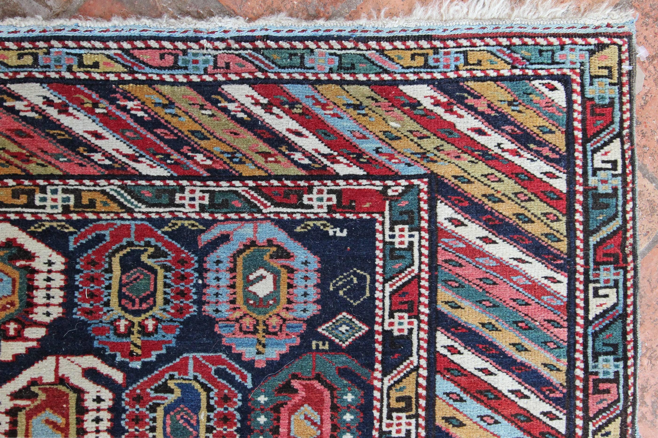 An antique Kuba rug in fantastic original condition with beautiful colours and varying in design from mother and daughter Boteh motifs in the centre to a striped Genje border design. The weaver of this vibrant and interesting antique Caucasian rug