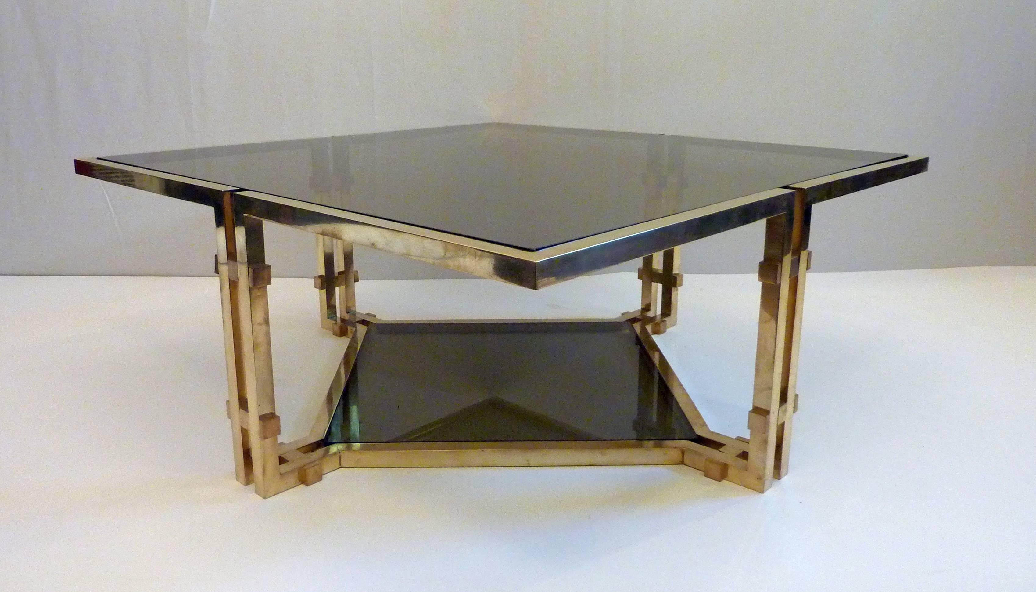 Solid coffee table designed by Romeo Rega. The coffee table has a brass structure with smoked glass square top as well as a bottom level with glass as well. Square bolts is holding the structure together.