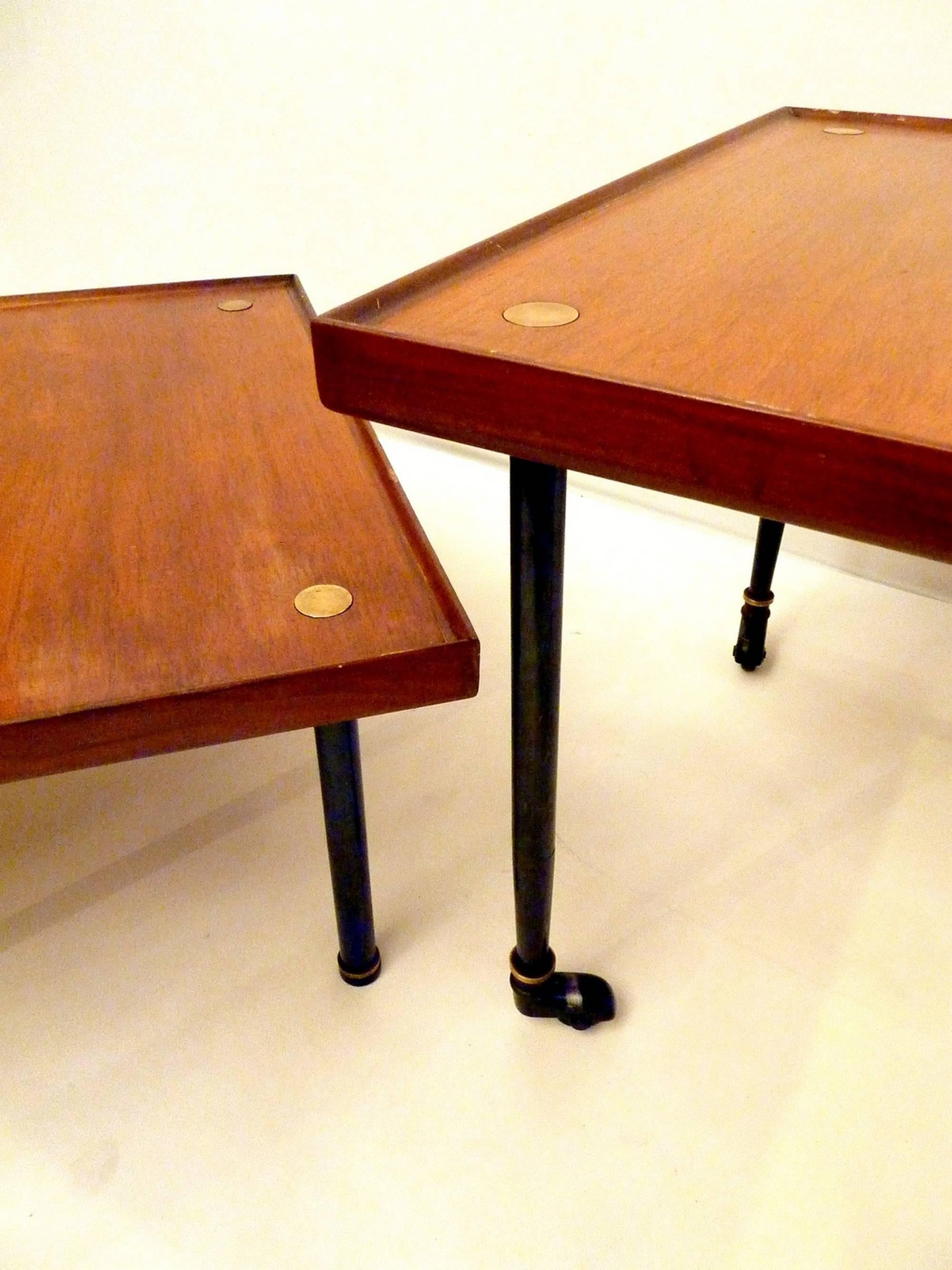 A pair of rarely seen Melchiorre Bega side tables in teak and brass. Produced by Klan, Italy. The tables are executed in two different manners. One has wheels and is higher than the other without wheels. One table is 50cm high and the other is 33cm