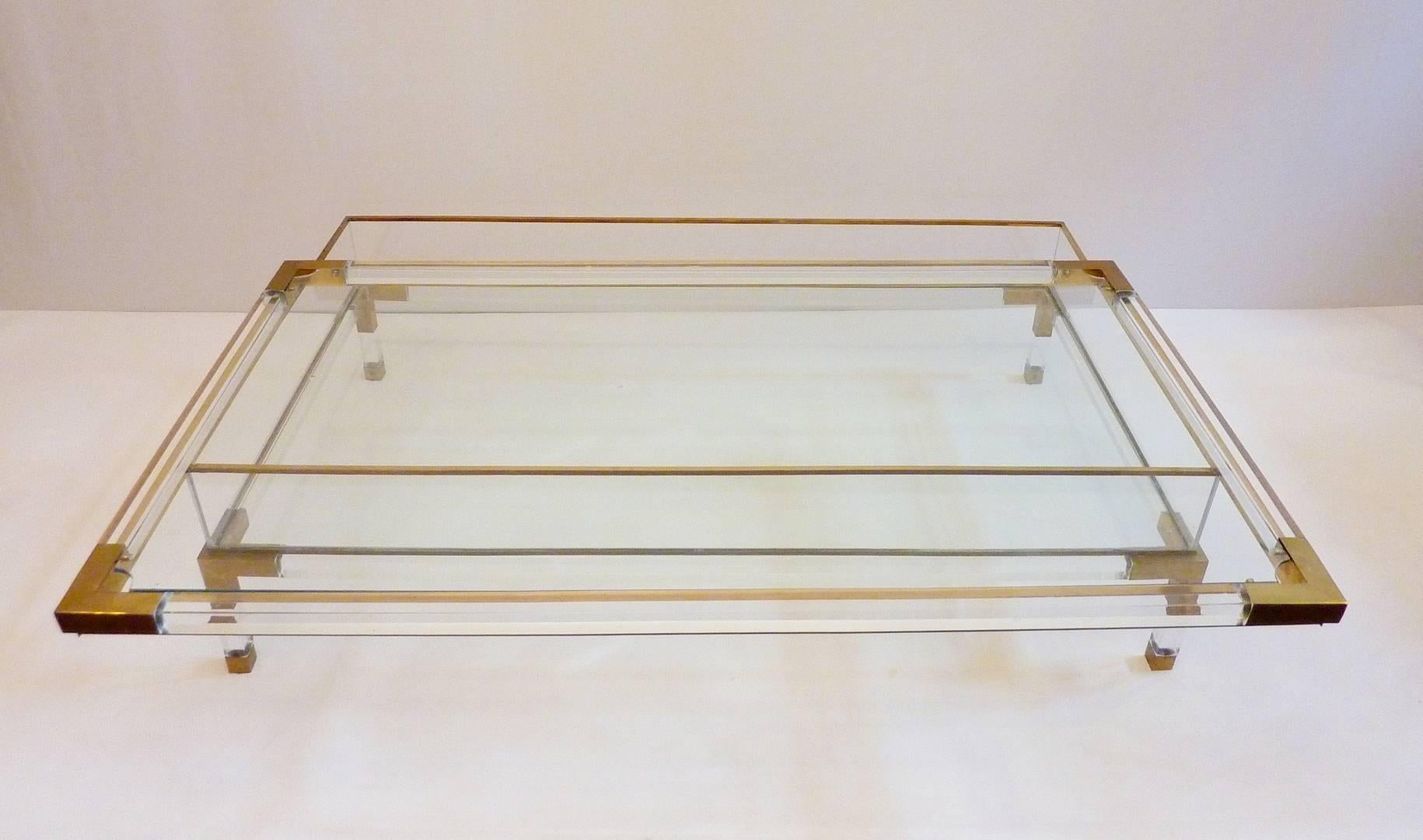 Rectangular coffee table in lucite and glass with brass corners and feet by Maison Jansen.