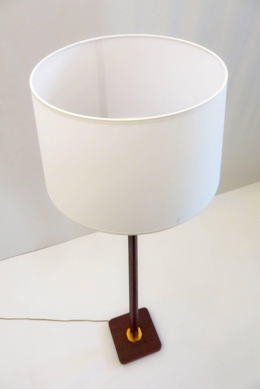 Midcentury floor lamp produced in Sweden in the 1950s. The base is square with an angular shape to the stem of the lamp. The top of the lamp can be tilted as well as standing straight up. Comes with a new crisp white lampshade with a diameter of 35