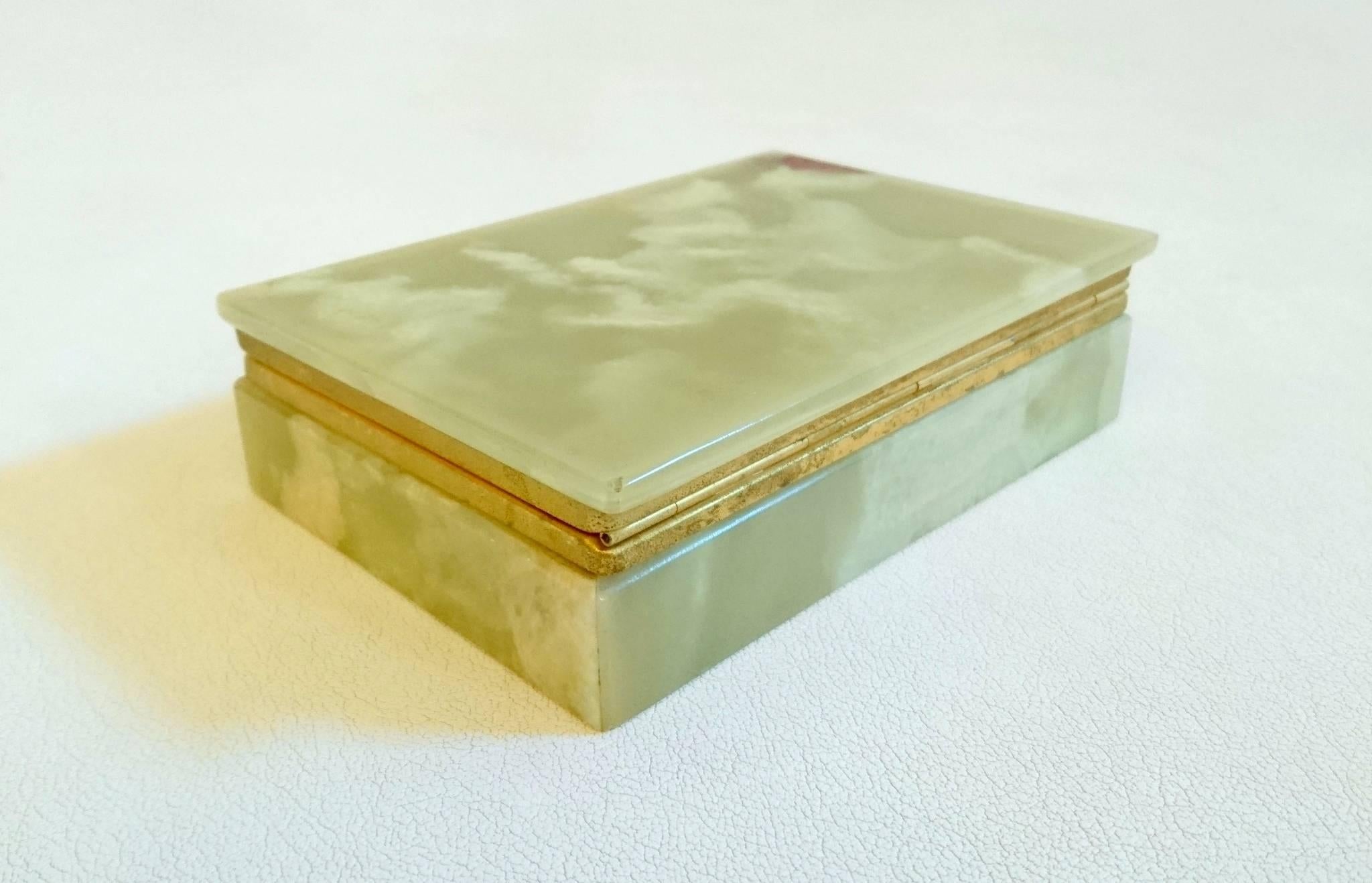 Trinket or jewelry box with a lid on hinges. Made all in onyx and brass gilded in gold. The onyx has a range of colors and in this particular case you can see brown on the top of the lid which is completely natural.