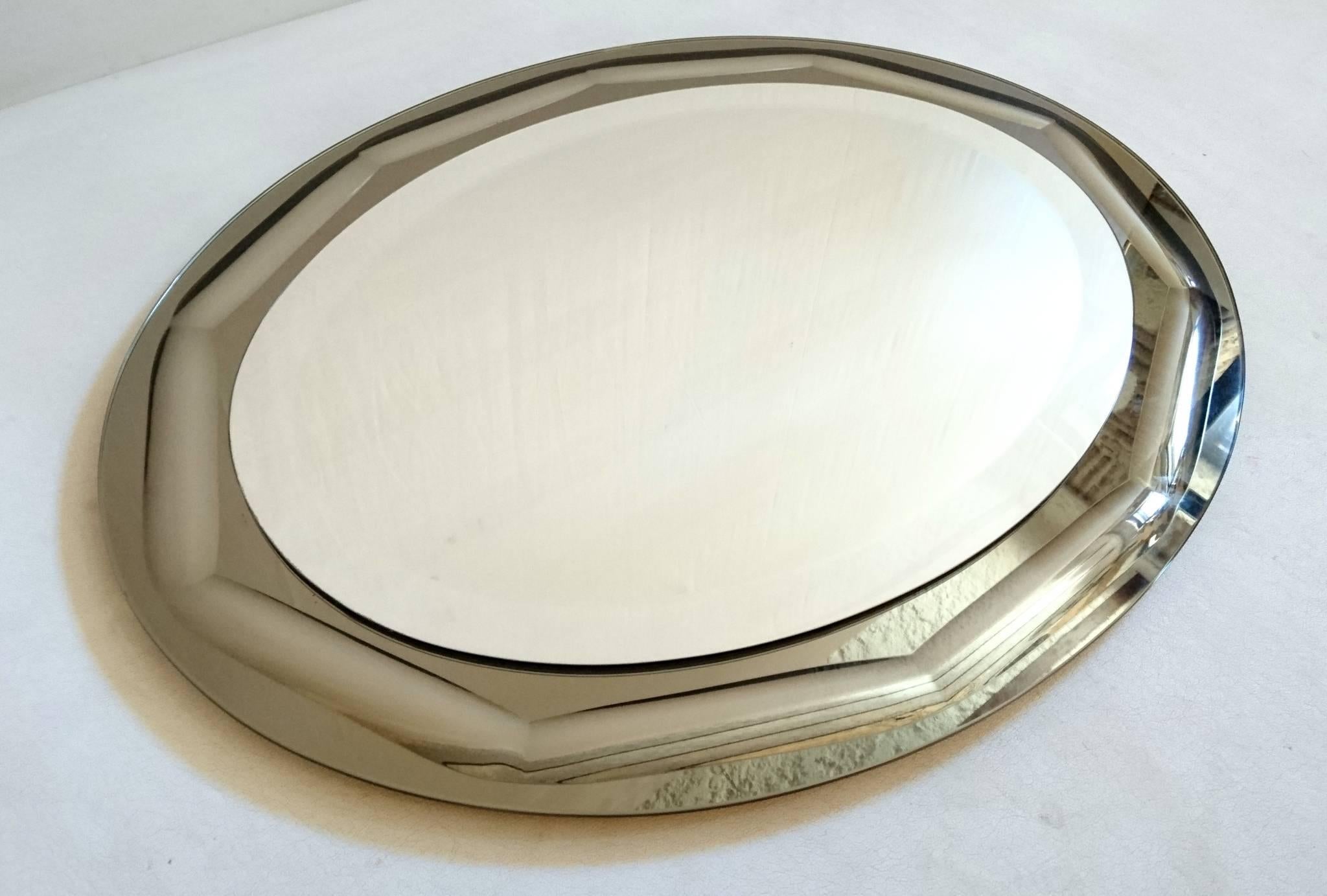 Vintage Italian oval, all glass mirror by Cristal Lupi Luxor (Antonio Lupi). The main bevelled glass plate is mounted onto an oval smoked, silvery colored glass frame, which in some lights looks a silvery beige. Can be hung in landscape or