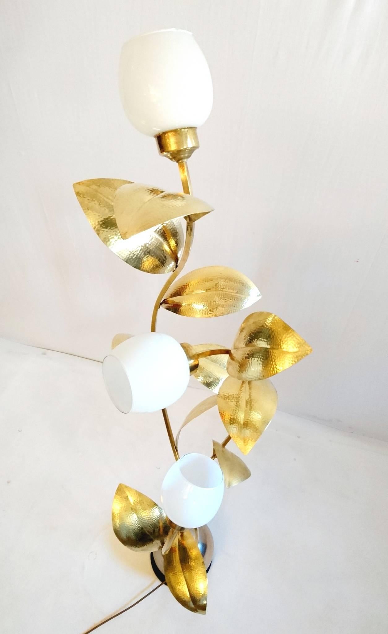Floor lamp with three stems attached to a round ball, adorned with handmade brass leaves and white glass shades. The leaves are marked AG.
