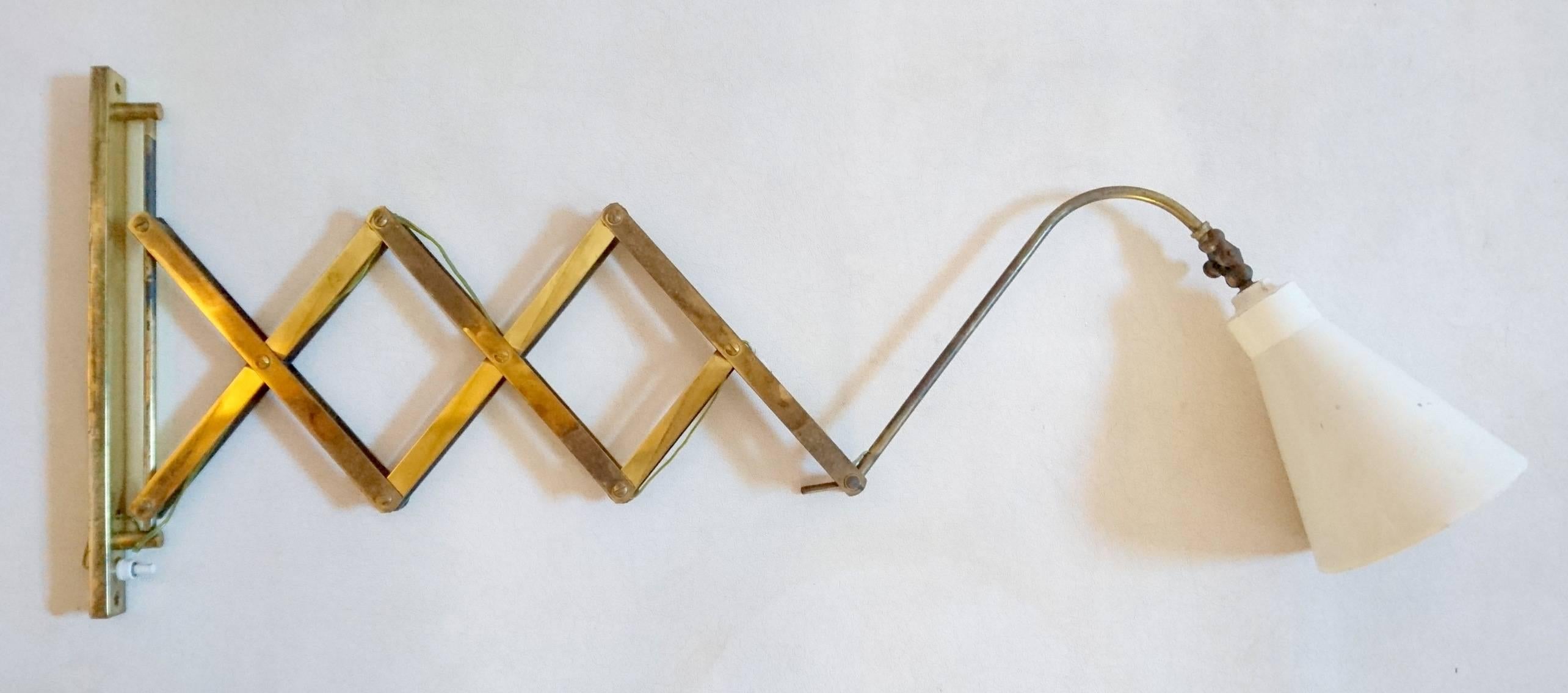 Extendable wall lamp in brass with a white lamp shade. Measures: Folded the lamp is 18 cm and extends to 110 cm maximum.