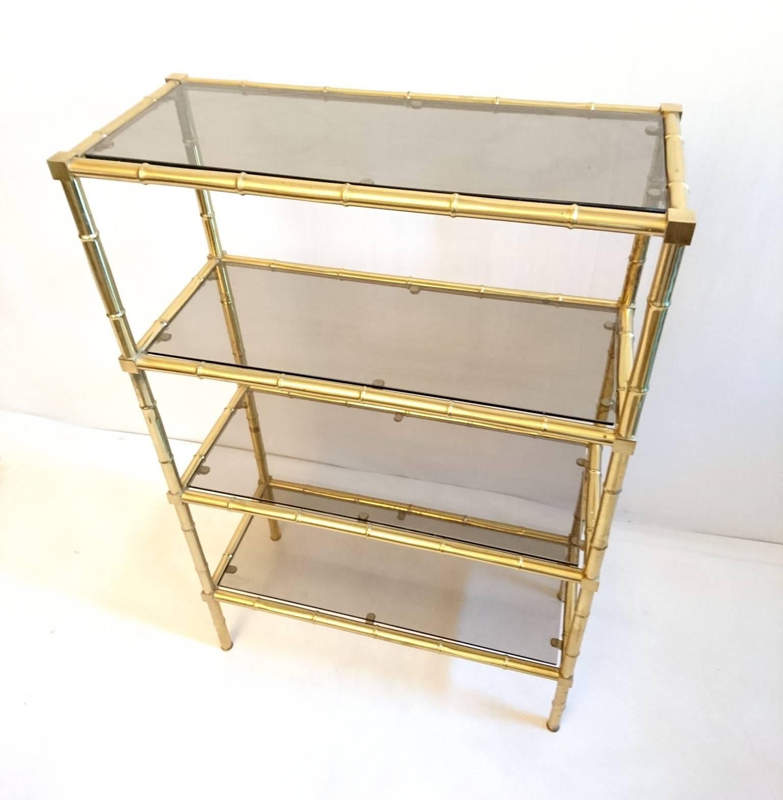 Four-tiered brass étagère/shelf in brass with smoke colored glass. Very stabile and solid.