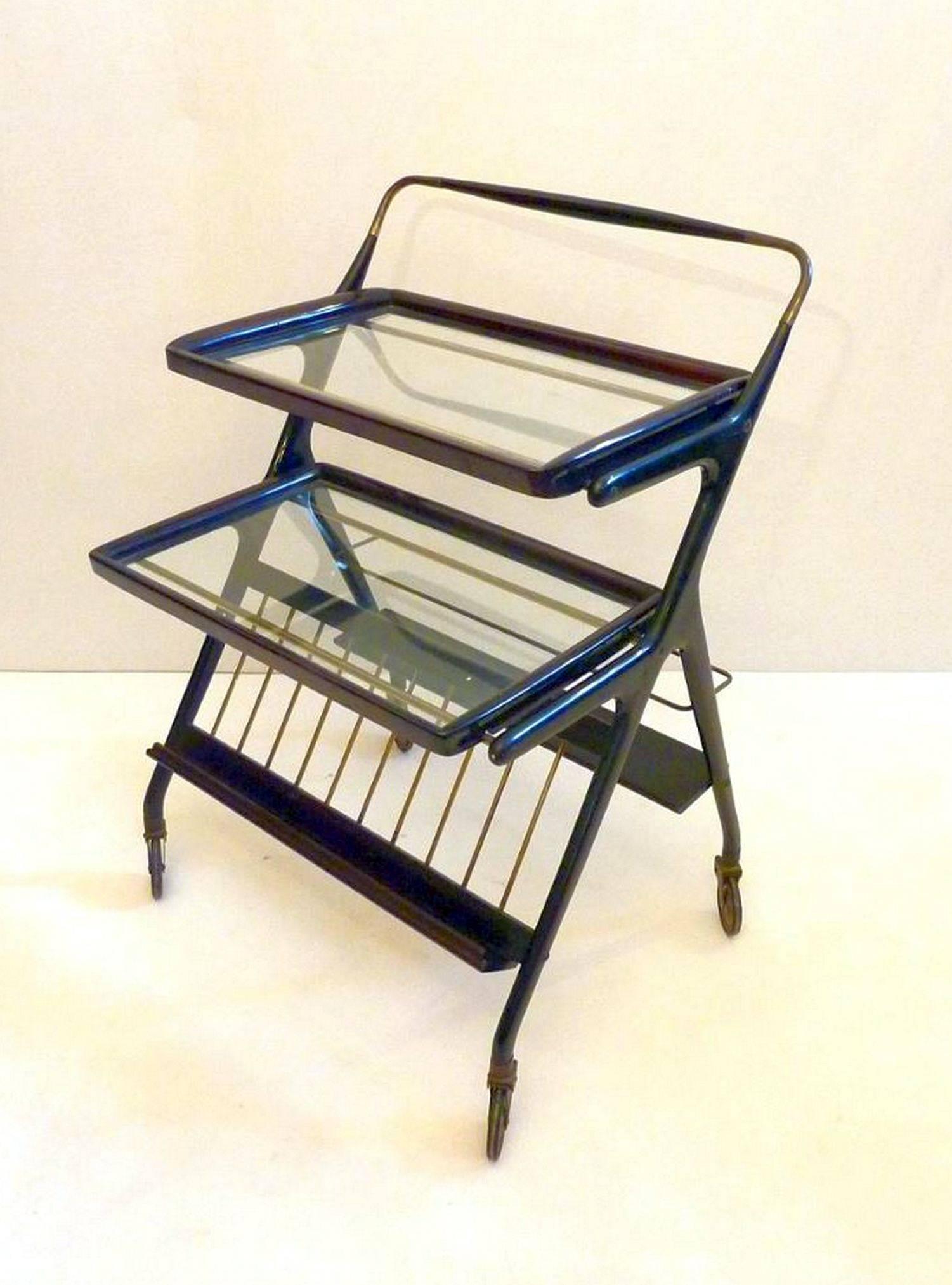 Multi-functional trolley with bottle rack, magazine holder as well as having two trays that both are removable. Original wheels in good condition. The structure is made in stained beechwood with brass details.