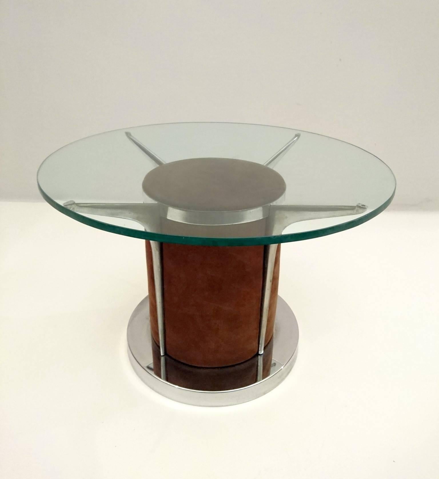 Round coffee table with a suede covered centre with the glass resting on four steel arms. In the pictures can be seen a smaller clear glass top with diameter 63cm. The original top is smoke colored with diameter 80 cm. As a buyer you are free to