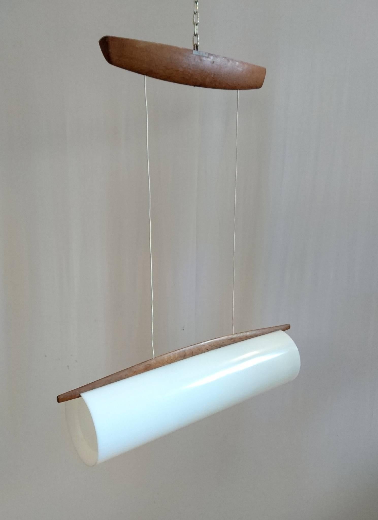 Cylindrical ceiling lamp adjustable in height and made from white plexiglass and oak. This lamp has model number 554, which is rare was designed by Uno and Osten Kristiansson. Produced by Luxus in Vittsjö, Sweden. The original sticker from the