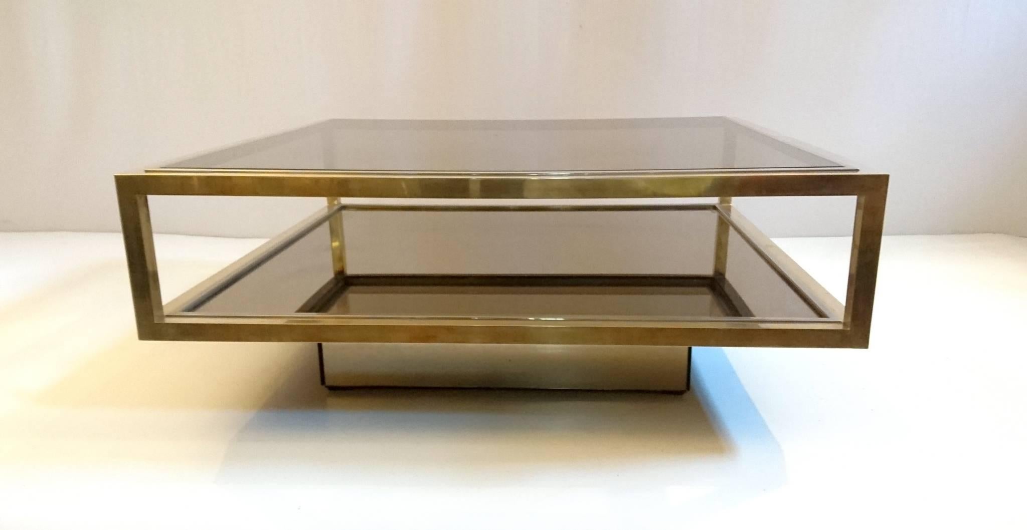 Elegant coffee table with two levels in glass and glass. The frame is made in brass and chrome and rests on a mirror covered base. Perfect for coffee table books. Excellent condition.