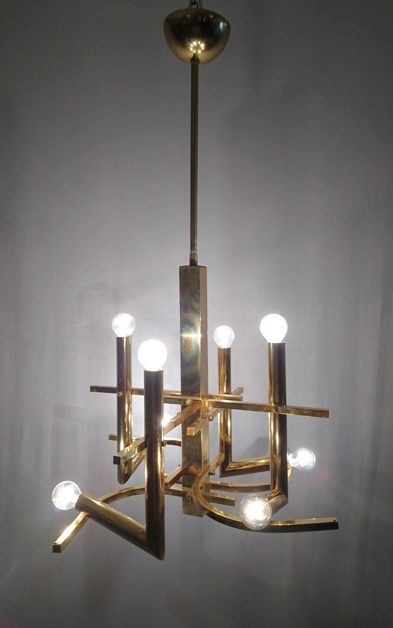 Unusual chandelier designed all in brass by Gaetano Sciolari with a total of eight lightbulbs. In full working condition. Measurement is with the rod included. Will work for American and European use.