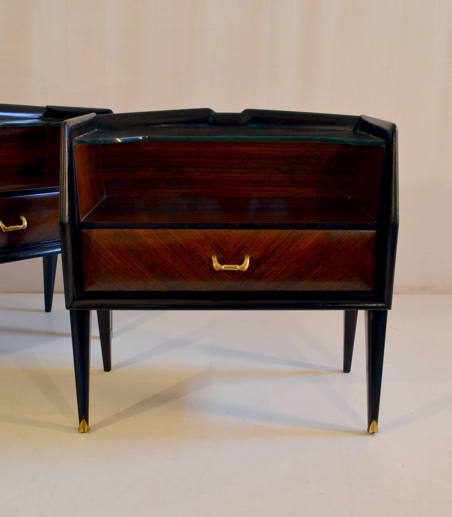 A pair of nightstands teak and blackened wood. With one drawer each and glass shelf and details in brass. In very good restored condition.