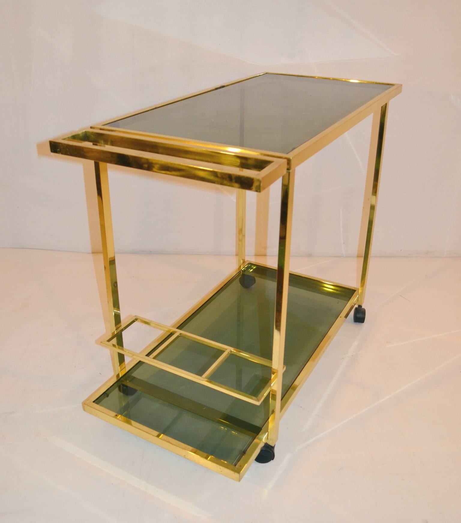 Elegant two tiered bar cart with bottle holder in brass and smoked glass.