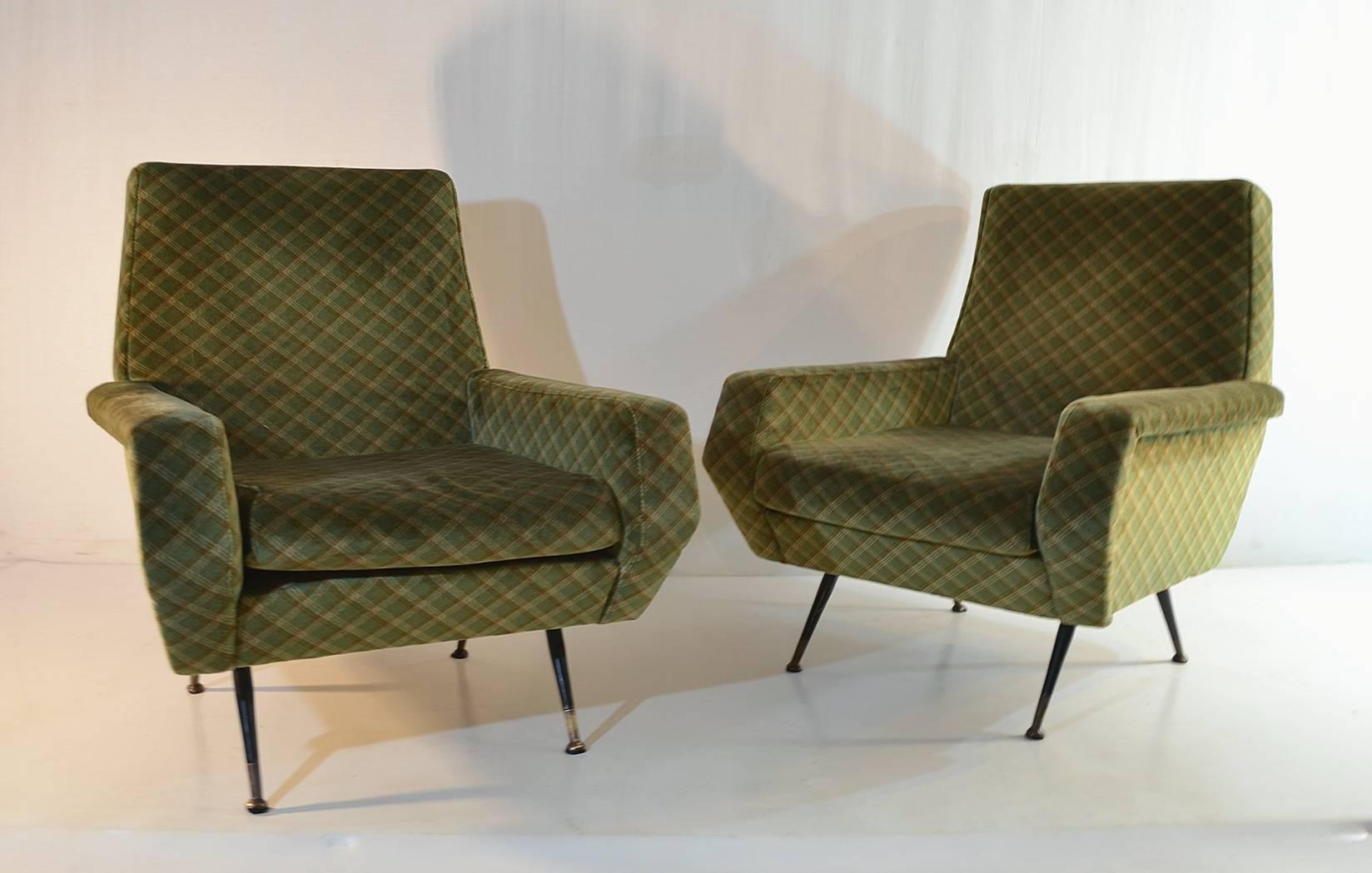 A pair of Italian armchairs in the manner of Marco Zanuso. The chairs have the original fabric and are in good condition. The legs are made from iron and has brass feet.