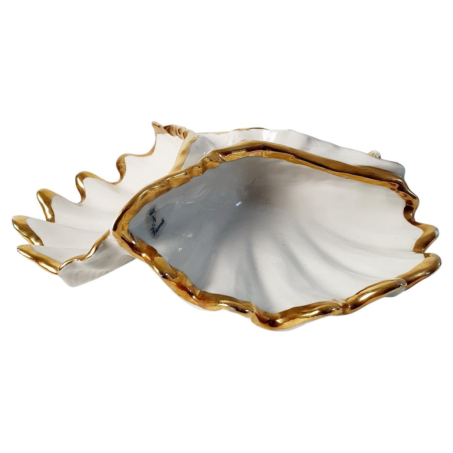 A shell bowl by Capodimonte in ivory white porcelain divided in three sections with gold edges. Marked with sticker Visconti and the crowned N. Perfect for different snacks or jewelry.
Some wear to the gold but no chipping.