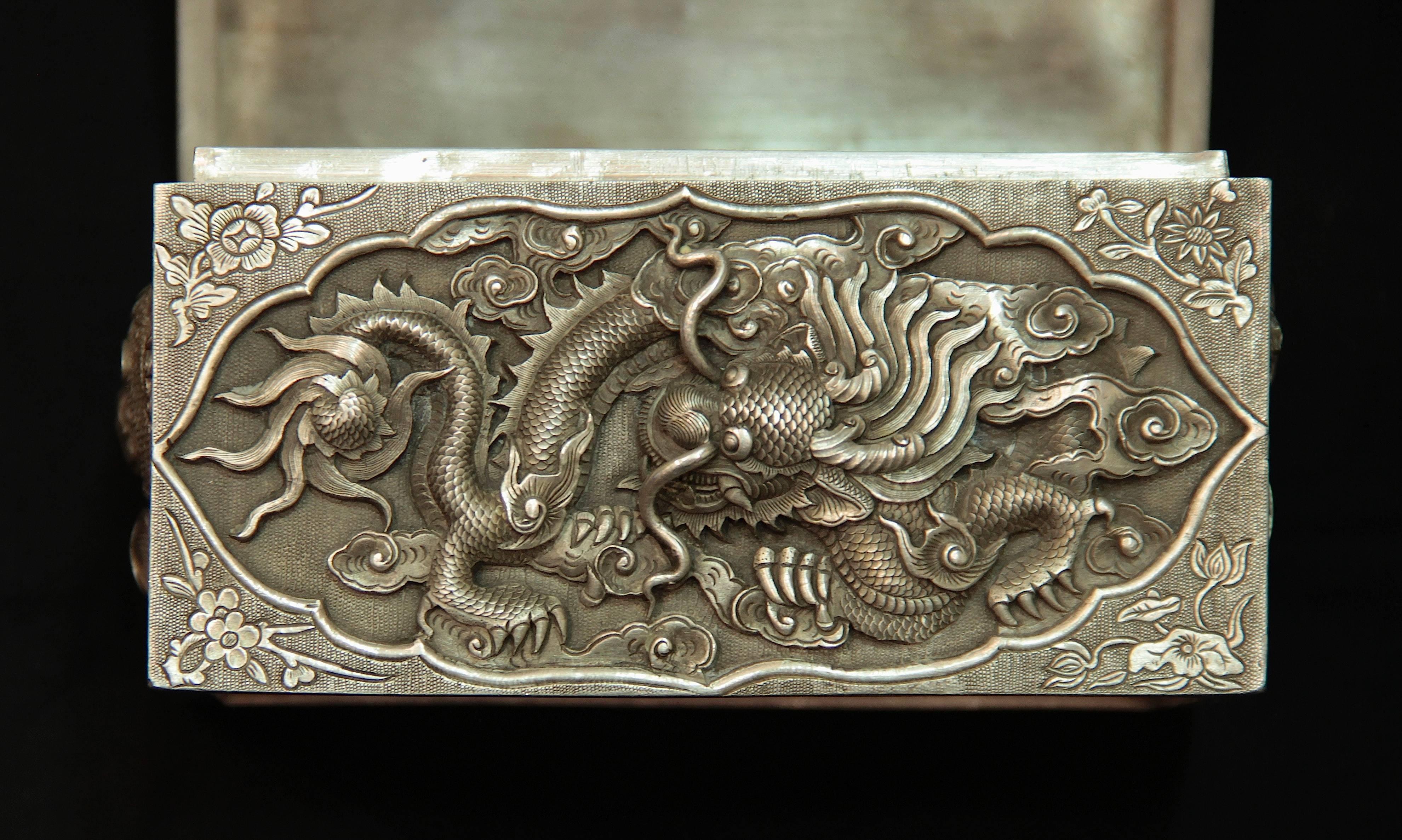 Box,
China, early 20th century.
Engraved silver
Measures: 7 x 12 x 8.5 cm.
Decorated with dragons and inscription.