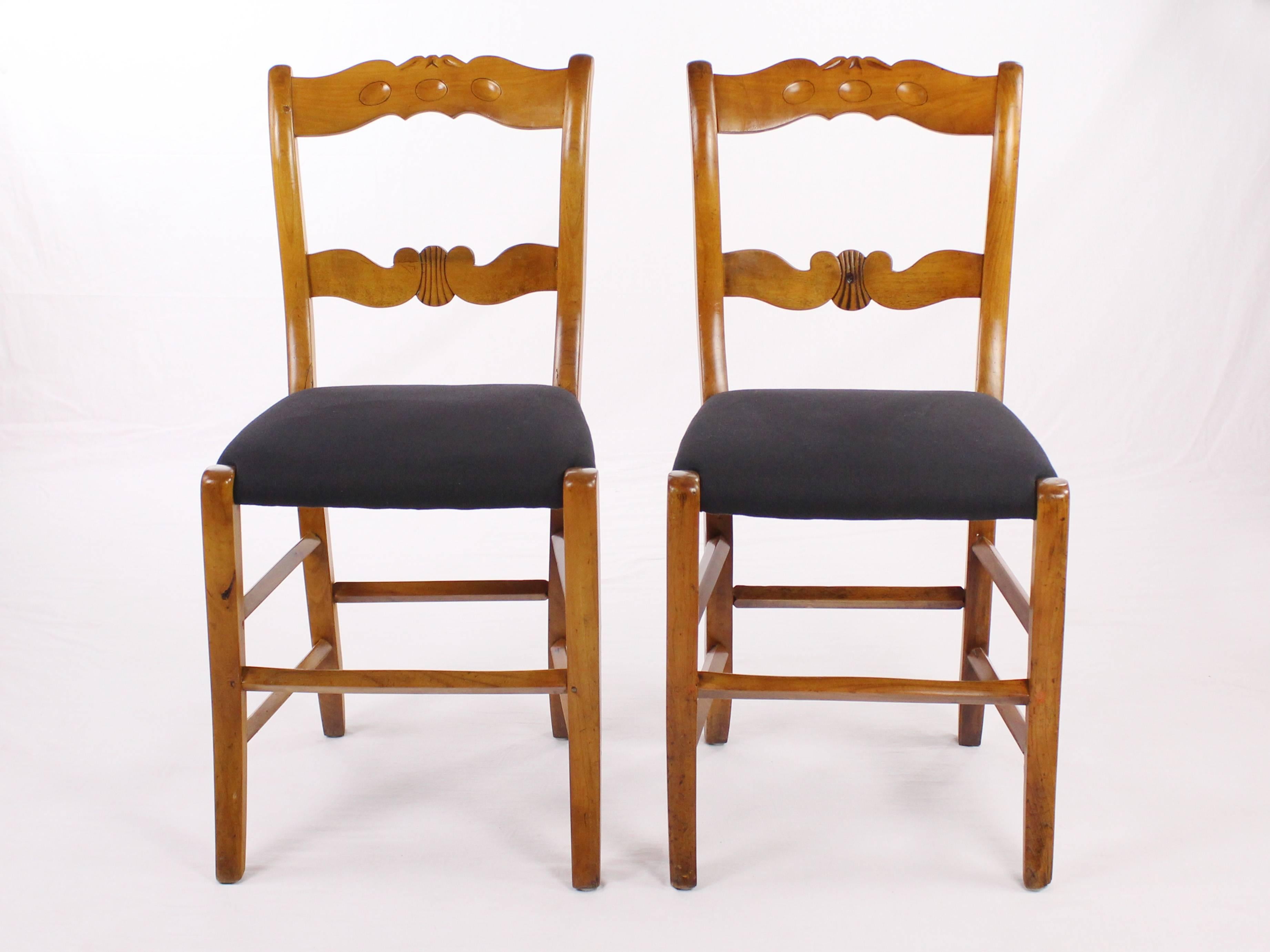 Set of 4 chairs made of solid cherrywood, made around 1830-1840 probably in Hessen or southern Germany. The legs of the chairs are slightly concave. The seat of the chairs was newly upholstered and covered with a black cotton fabric. The backrests