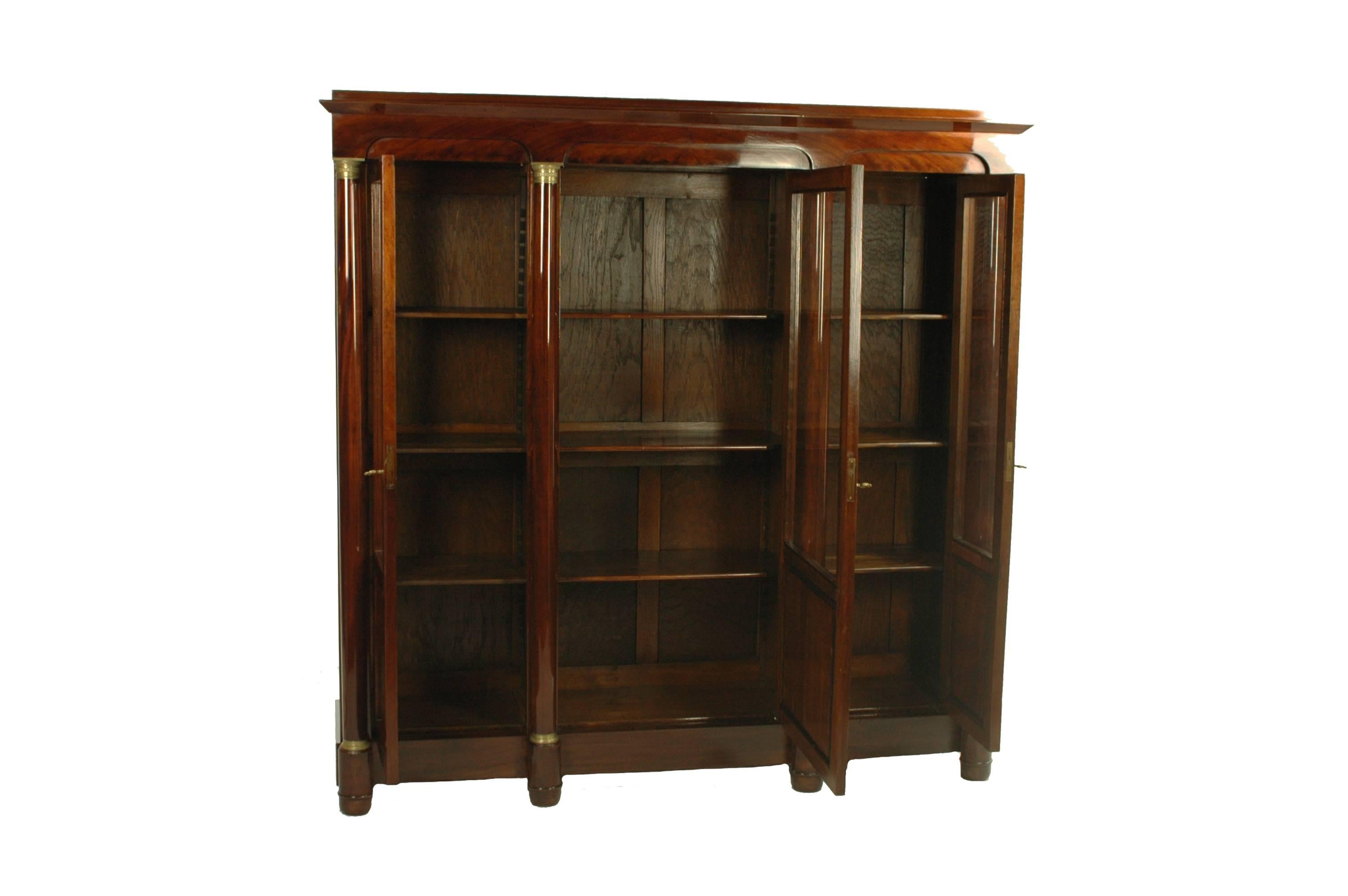 Unique and rare late Biedermeier period glass cabinet circa 1850 crafted in mahogany veneered. It is in perfect original condition, only the glass has been renewed during the restoration progress. The larger middle door and the 2 smaller doors to