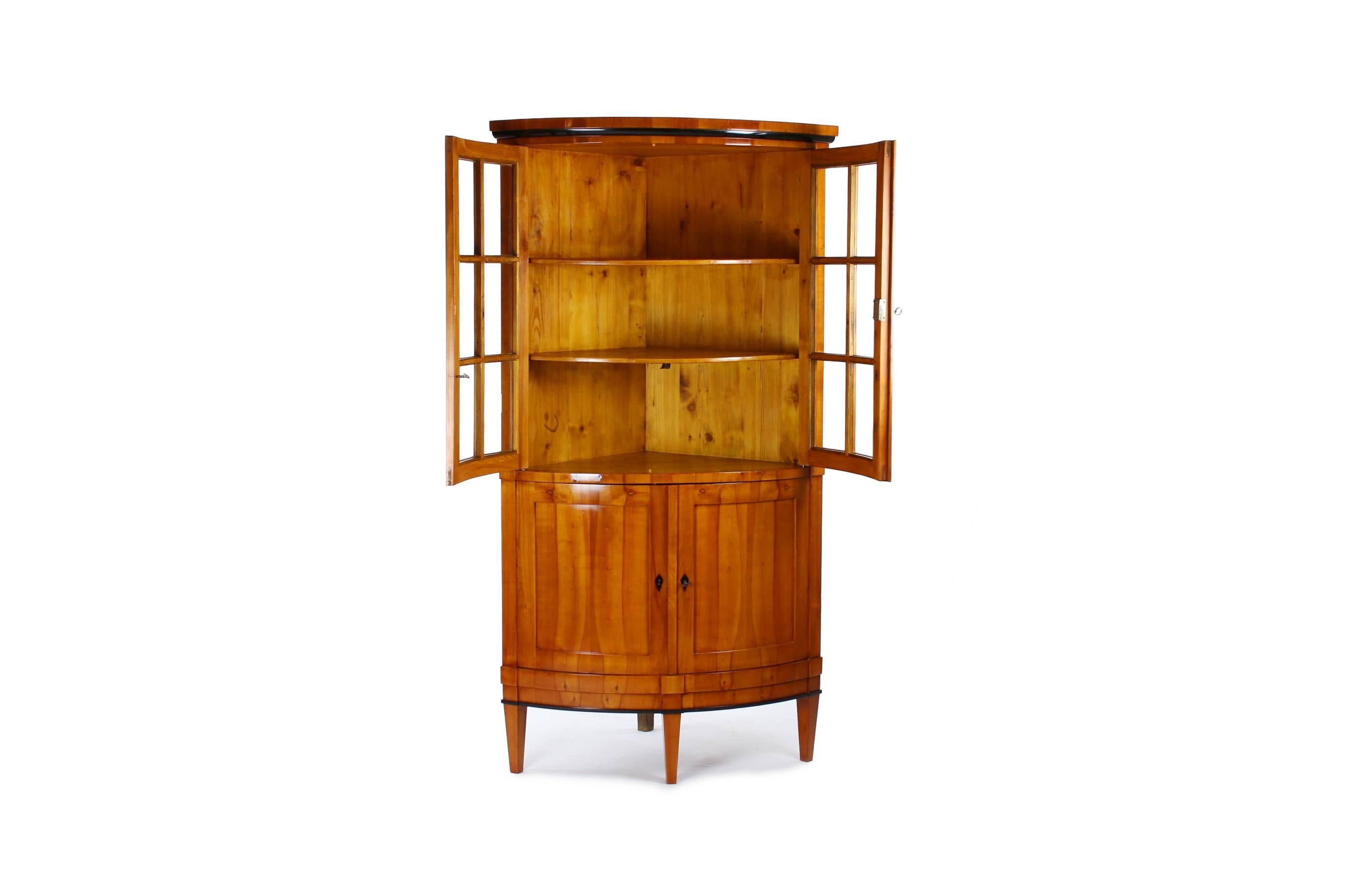 Biedermeier period corner cupboard,
circa 1830-1840.
Cherrywood veneered.
Parts ebonized.
Top front-glazed two-door.
Two-door drag with cuddy.
Restored residential-ready state.
Shellac polish.

I dispatch by air in safe wood boxes only. So