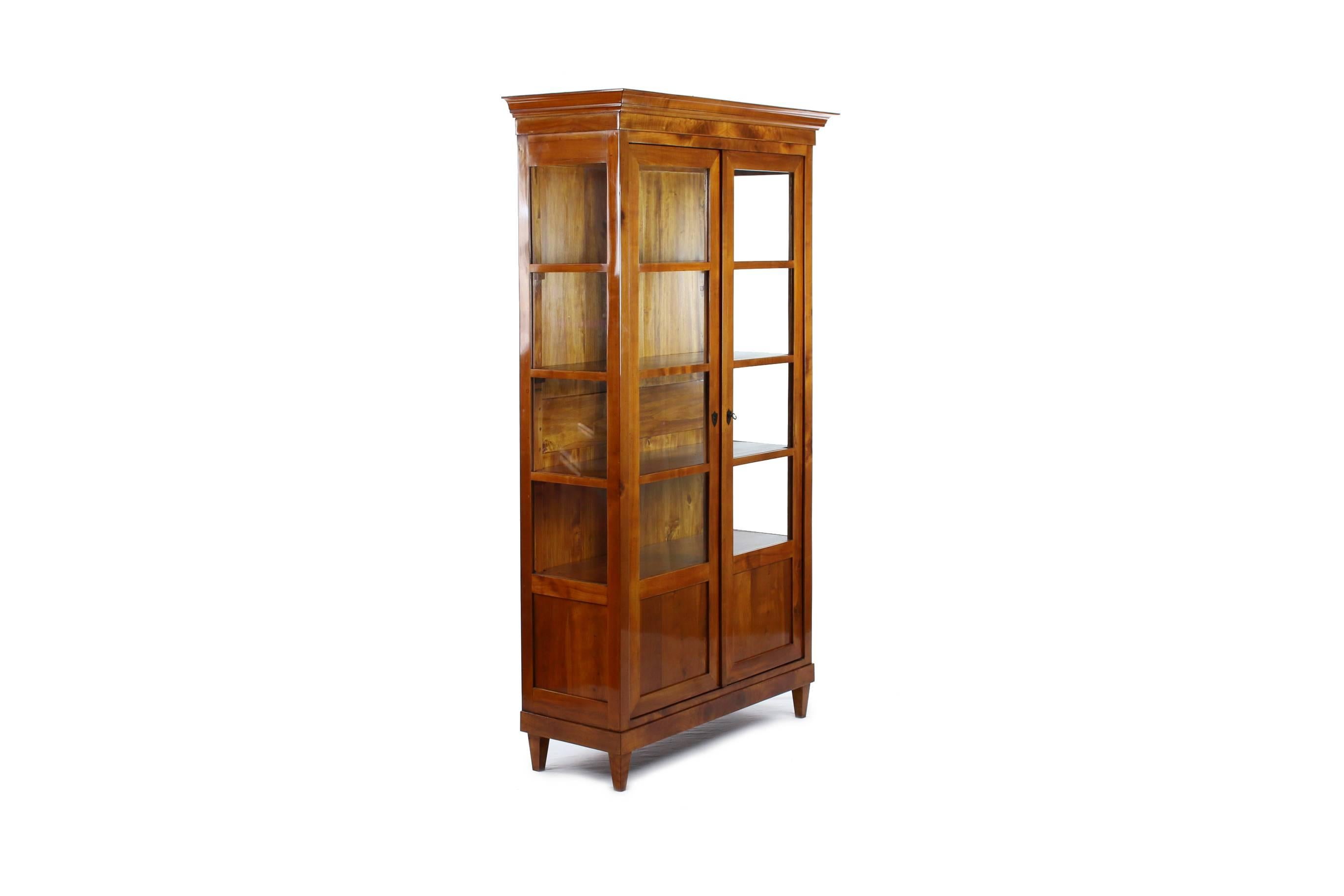 Biedermeier period corner cupboard, 
circa 1830-1840.
Cherrywood veneered.
Parts ebonized.
Top front-glazed two-door.
Two-door drag with cuddy.
Restored residential-ready state.
Shellac polish.

I dispatch by air in safe wood boxes only. So