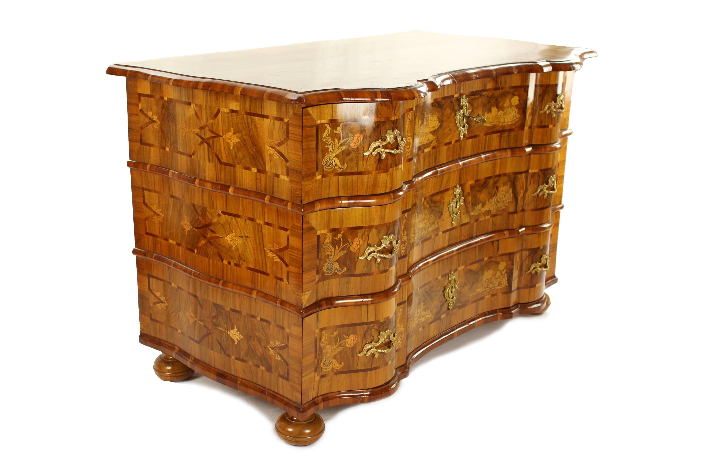 Baroque chest of drawers.
Erfurt, circa 1750.
Nut and nut root wood on softwood body veneered.
Three large drawers.
Twice embowed body with scenery inlaid works.
Original locks.
Restored residential-ready state.
Measures:- Height: 86 cm,
