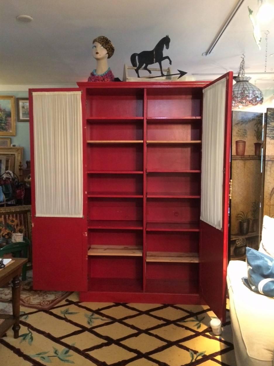 Painted a vibrant Ralph Lauren red! Fabulously chic re-cycled with flare closet! Once a Park Avenue Murphy's bed - now a great armoire or closet or cupboard. The doors are adorned with fabulous farmhouse chicken wire, custom-made curtains and