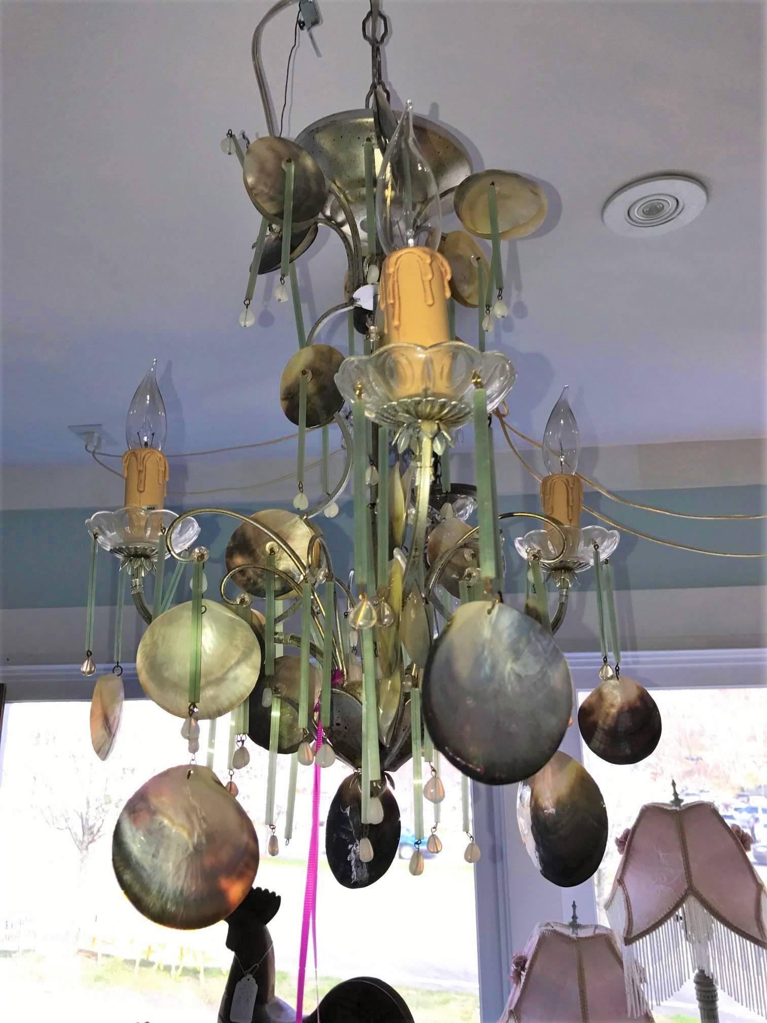 Eye-catching dazzler! Petite antiqued coastal cottage chandelier great sea shell ornaments and Murano crystals. Fabulous mix of diversified seashell's from around the globe. Sage crystal's add a soft glimmer to this petite estate piece.

A larger