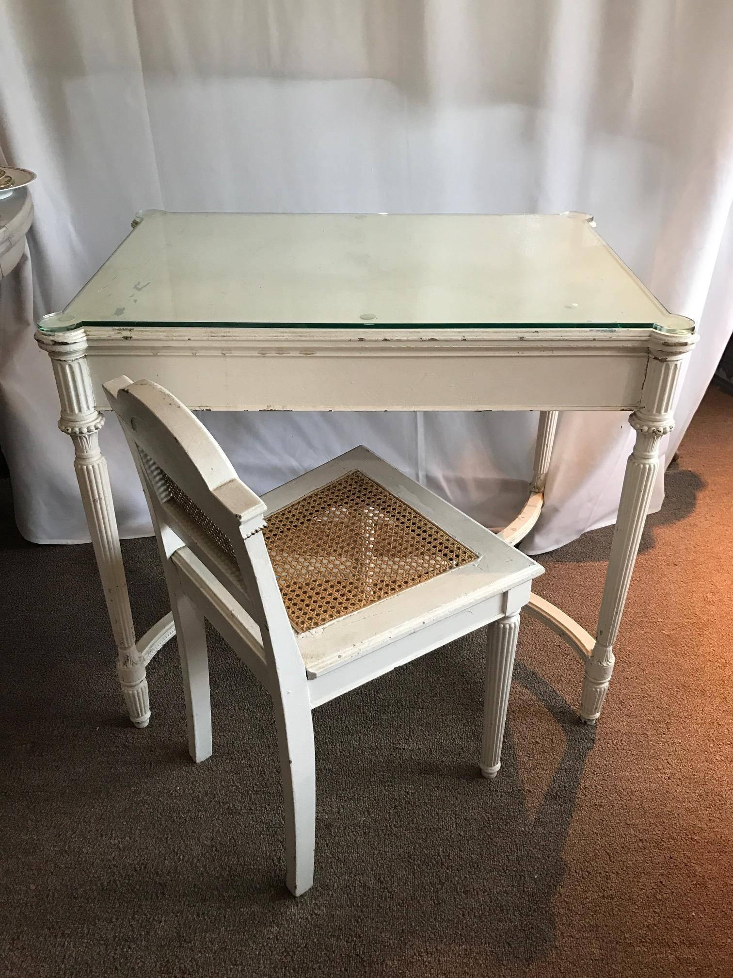 On Sale Now!  Maison Jansen style Fantastic Louis XVI hand-carved vanity/desk glass top and gilt chair. Fluted legs double C Form stretchers on the bottom of the vanity leading to a glass top, White Shabby Chic Flare, gilt canned seat with Medallion