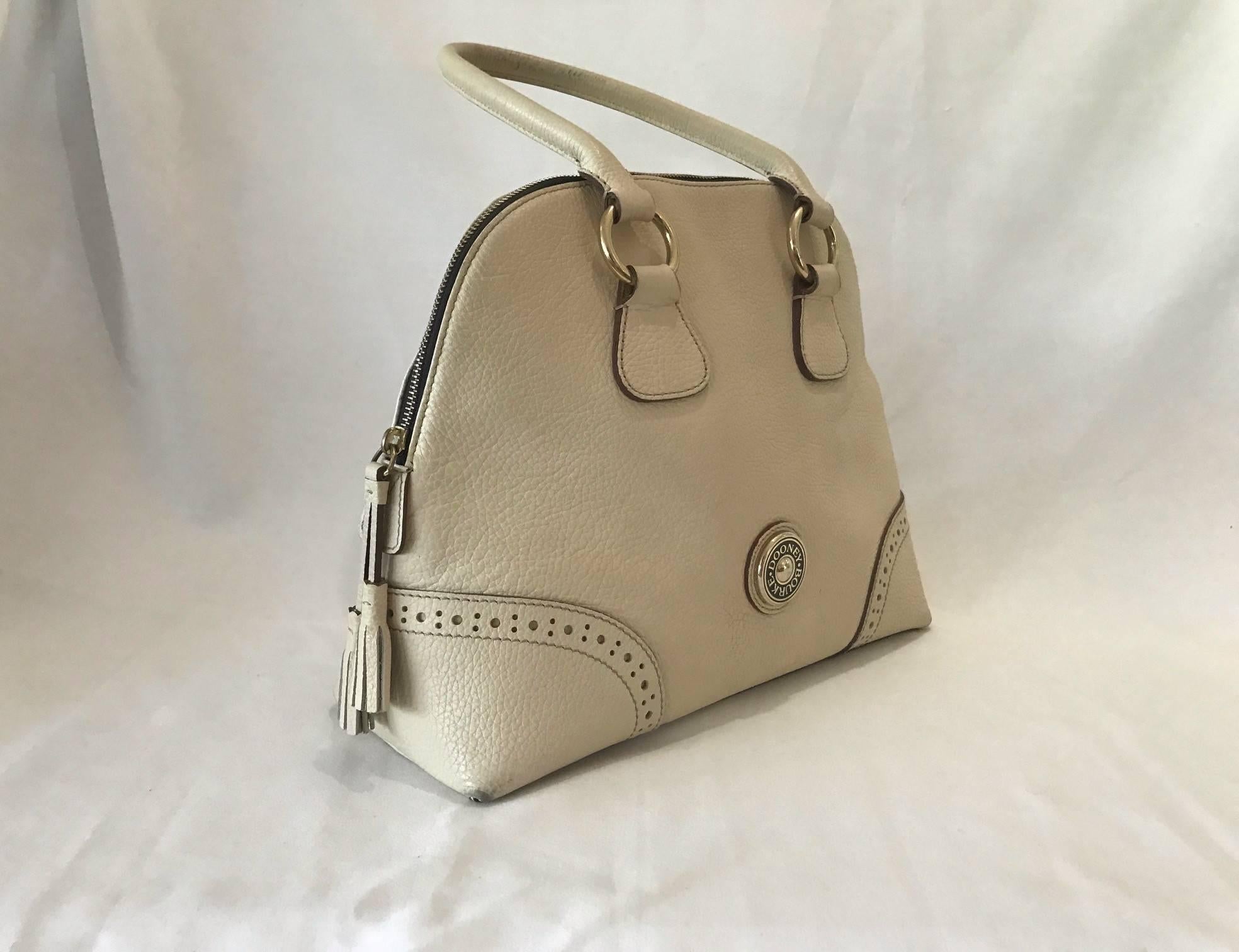 Authentic crème colored Dooney Bourke leather hand bag, clean, Rarely Used. Soft Salmon Tweed Interior. Like New.