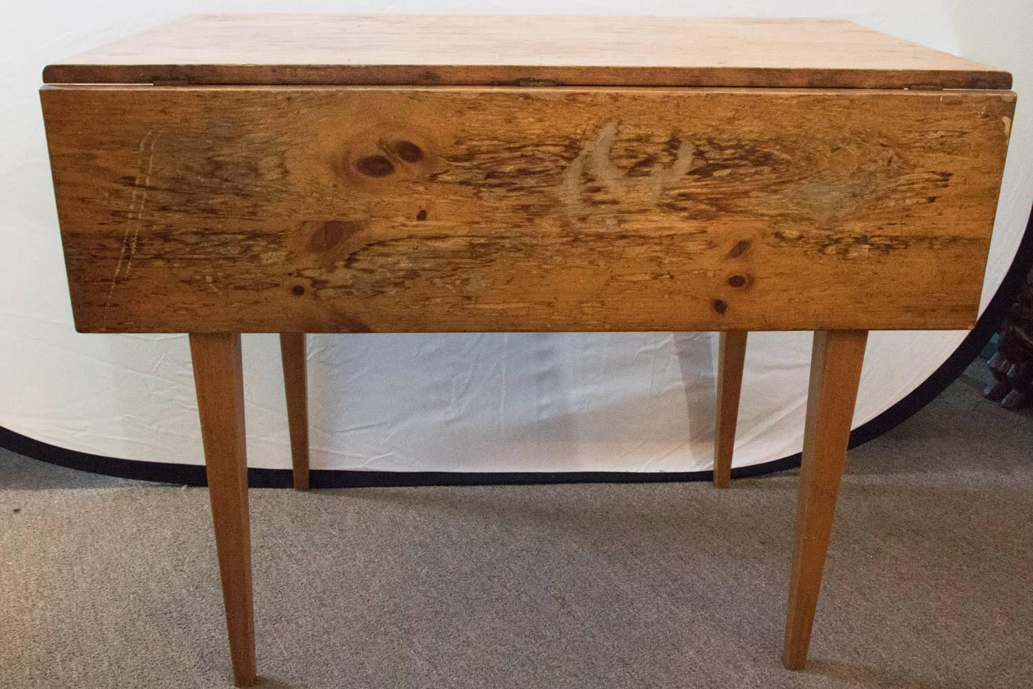 Fabulous Petite French farmhouse table reclaimed pine drop-leaf, 19th century. A beautiful farmhouse table built using rough timbers and native woods. This is a strong and enduring piece that gains beautiful character over time.

Measurements: 36 L
