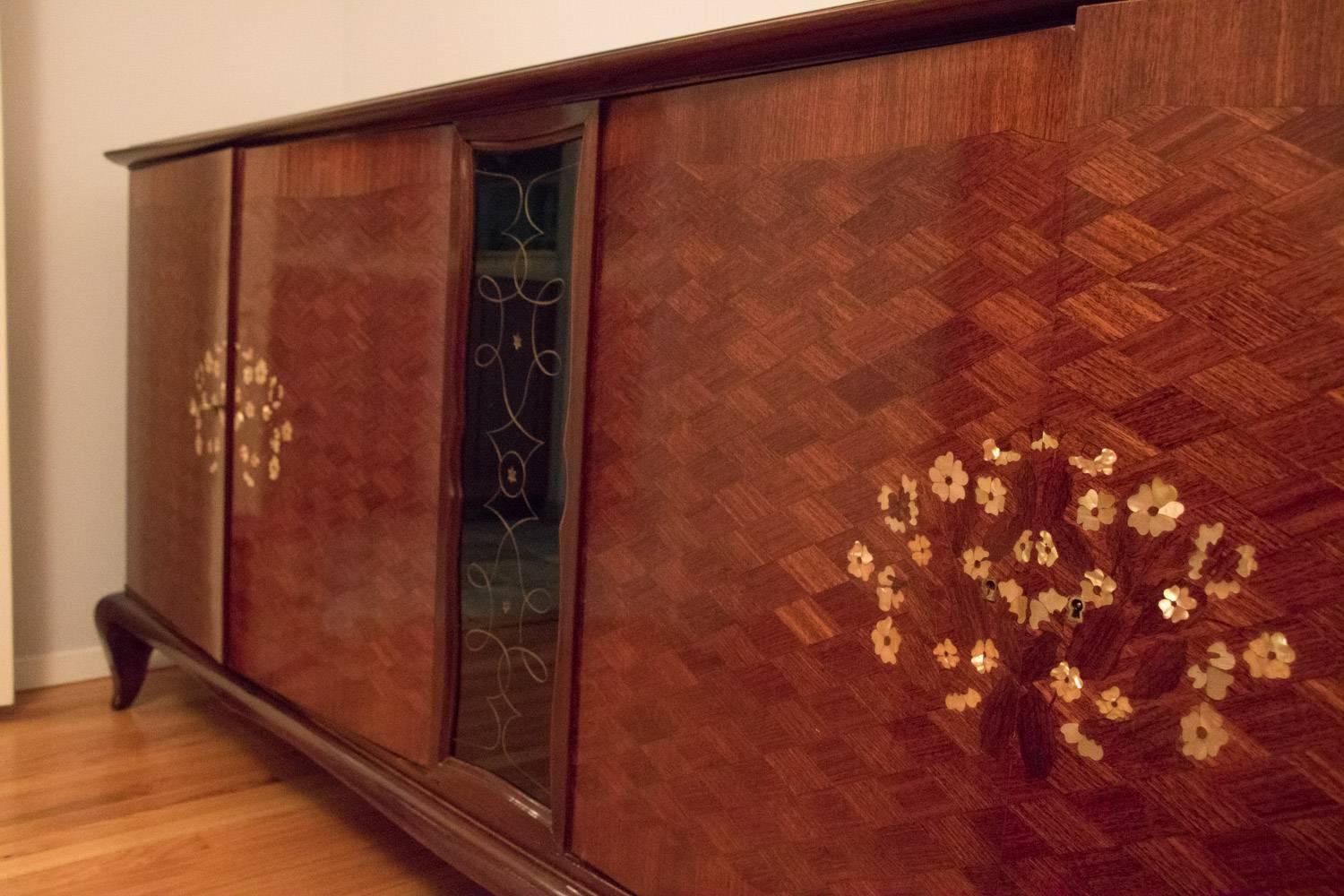 Mid Century Modern Rare Brazilian Rosewood Deco Sideboard!  Stunning Inlay Jules Leleu Style. 
Stunning Mother of Pearl Inlay Design Circa 1940. 
Made of Solid Gorgeous and Rare Brazilian Rosewood.  Fabulous Storage Shelving and Drawers all Rare and