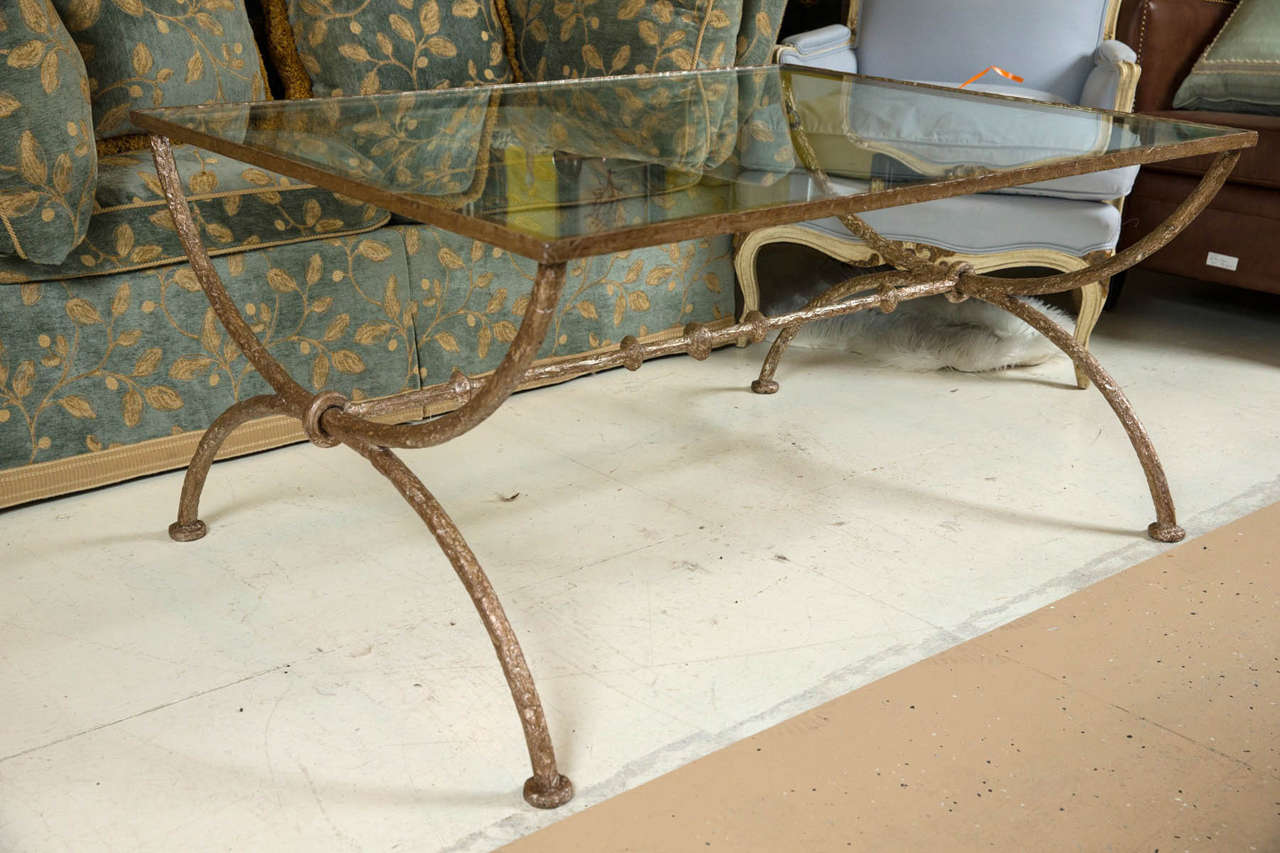 Wonderful wrought iron glass coffee table. Diego Giacometti style wrought iron coffee or low table. The sculptured design is quintessential Giacometti style. The grace and solidity of the wrought iron representing a solid rustic curved double