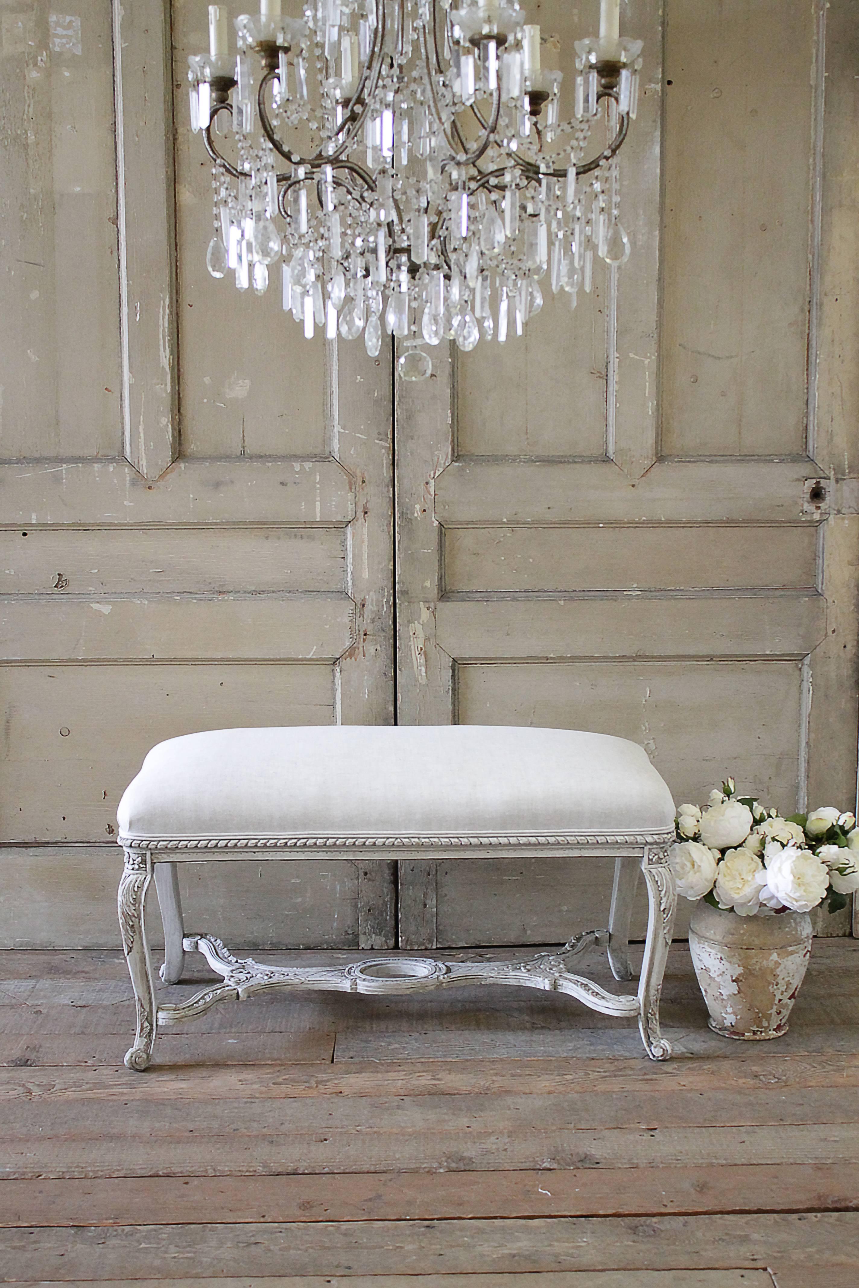 Lovely French style bench painted in our oyster white finish, with distressed edges and hand rubbed antique glaze. Coloring is off-white, with a grey hue. The top seat is upholstered in our natural Belgian linen. The natural is a greige color,