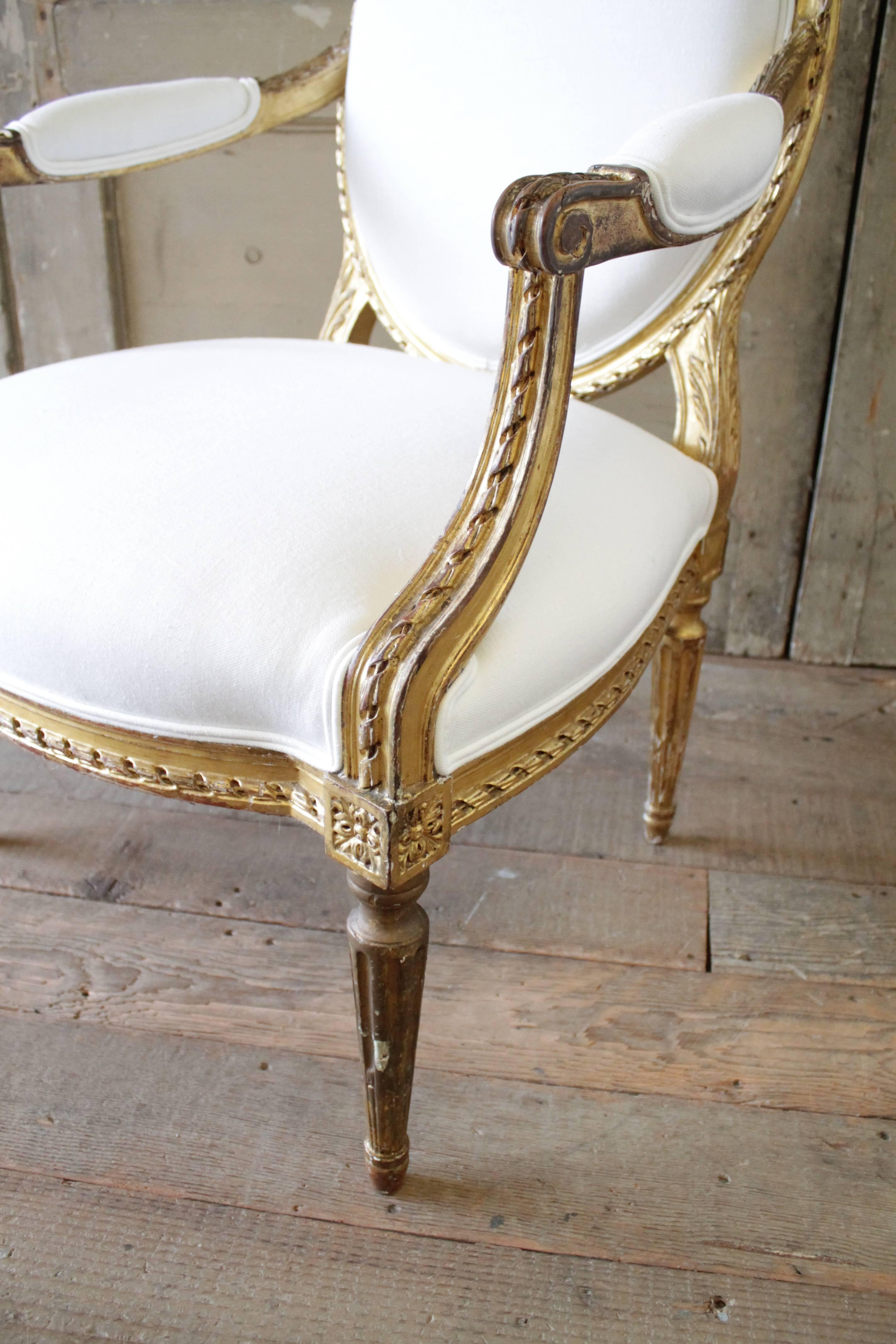 20th Century Carved Giltwood Louis XVI Style Open Armchairs In Distressed Condition In Brea, CA