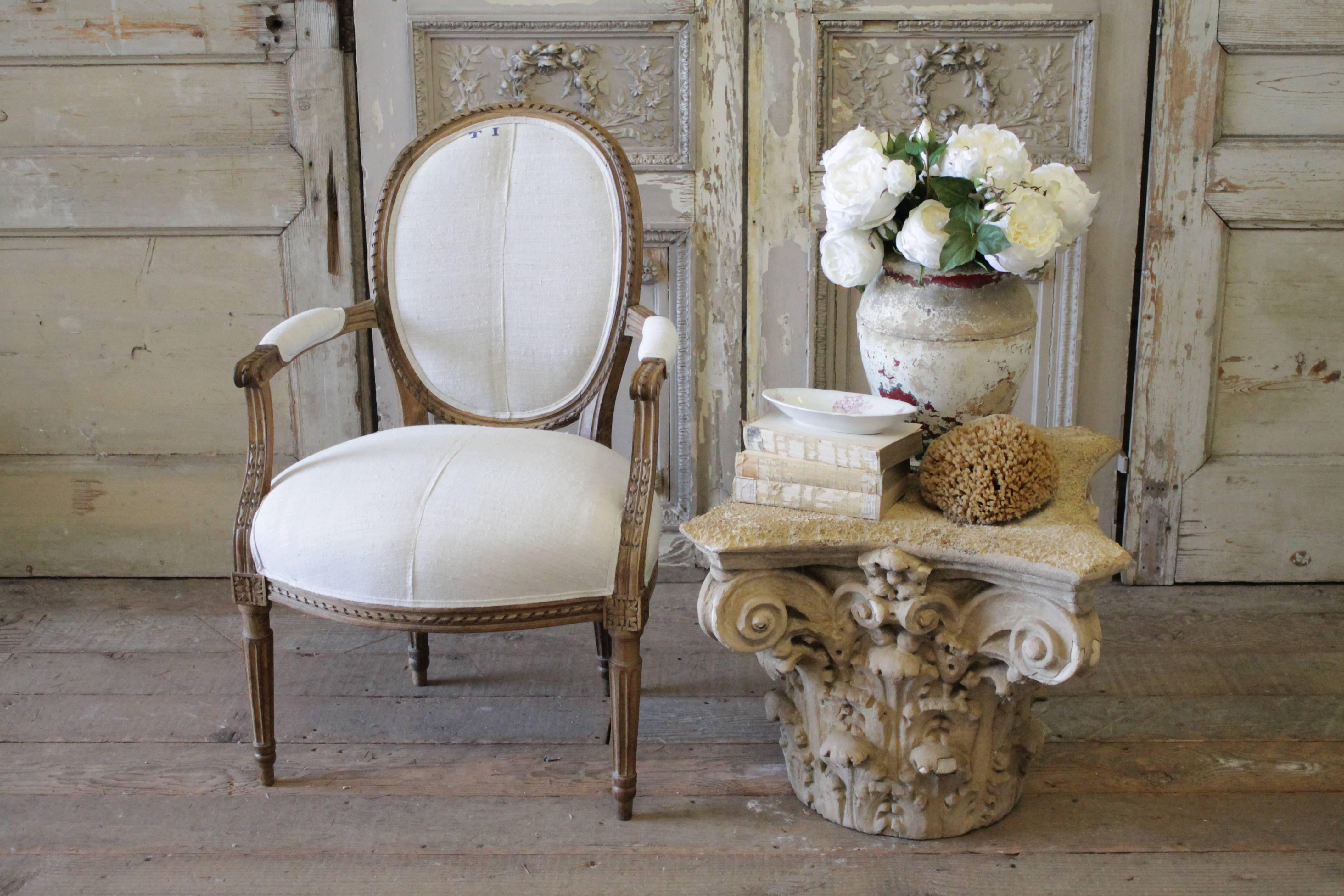 Beautiful carved walnut Louis XVI style chair. This open armchair is very solid and sturdy. It has been reupholstered in a 100 year old French Homespun linen, we have used the original hand-stitched seam on the linen down the center, and original
