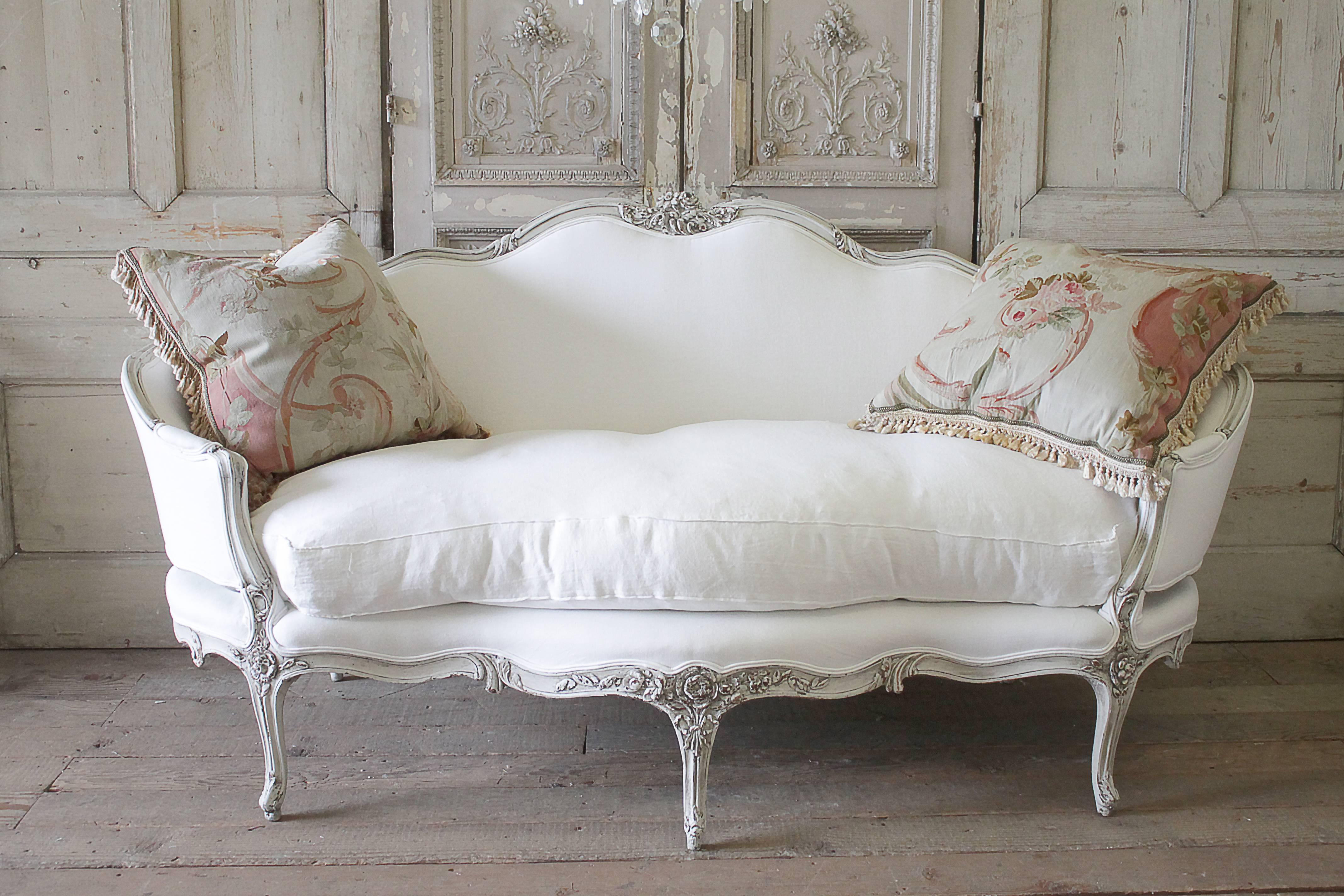 Exquisite French Louis XV style sofa with large carved roses, leaves and ribbons. We have refinished this sofa in a oyster greige finish with distressed edges, and antique patina. The color is pale grey finish with antiquing you would see if it were