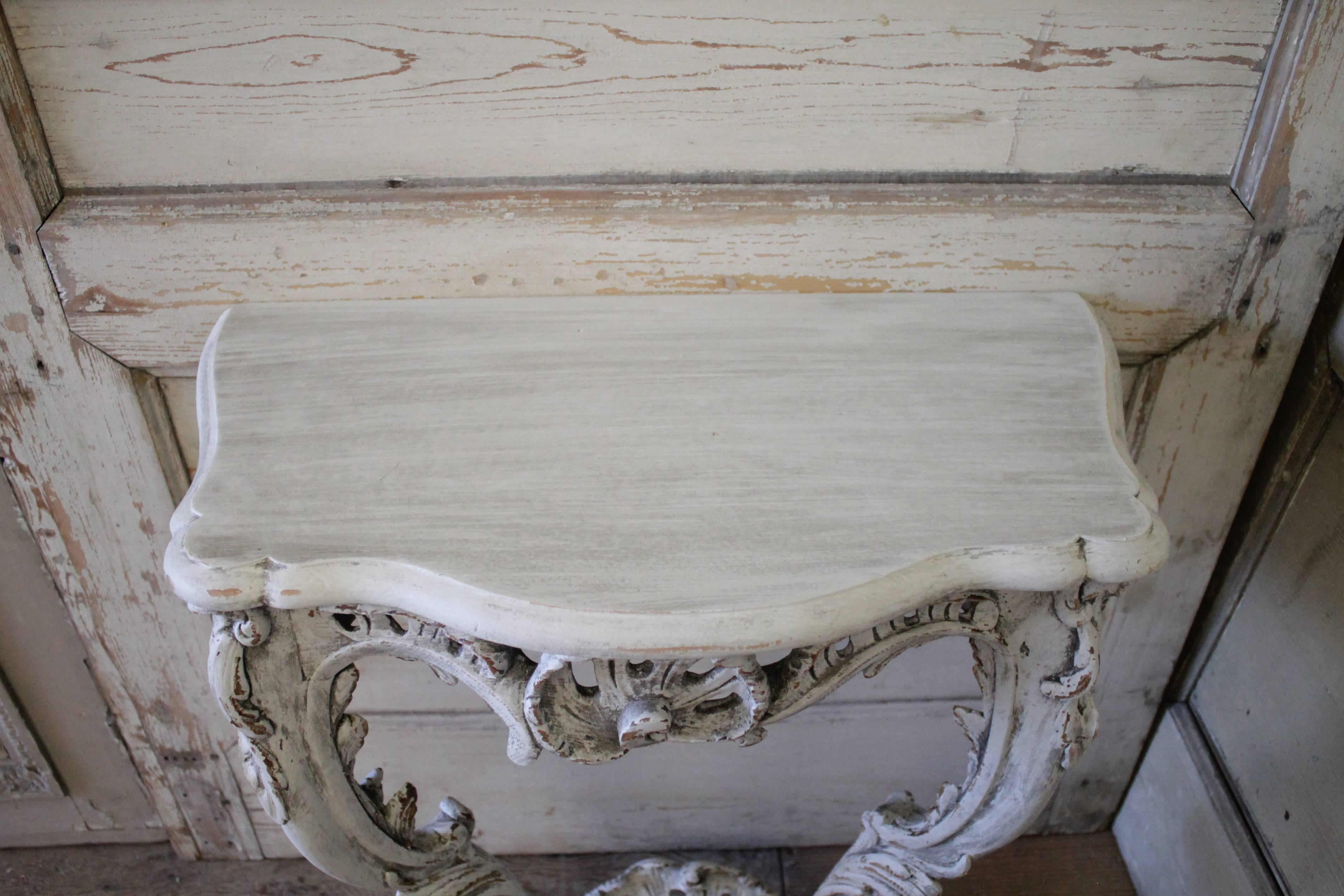 We have just 1 available.  Louis XV style wall consoles that have been painted in our oyster white with distressed edges, and hand glazed patina. The color is white with hues of grey.
Originally these would have had a marble top, but they have been