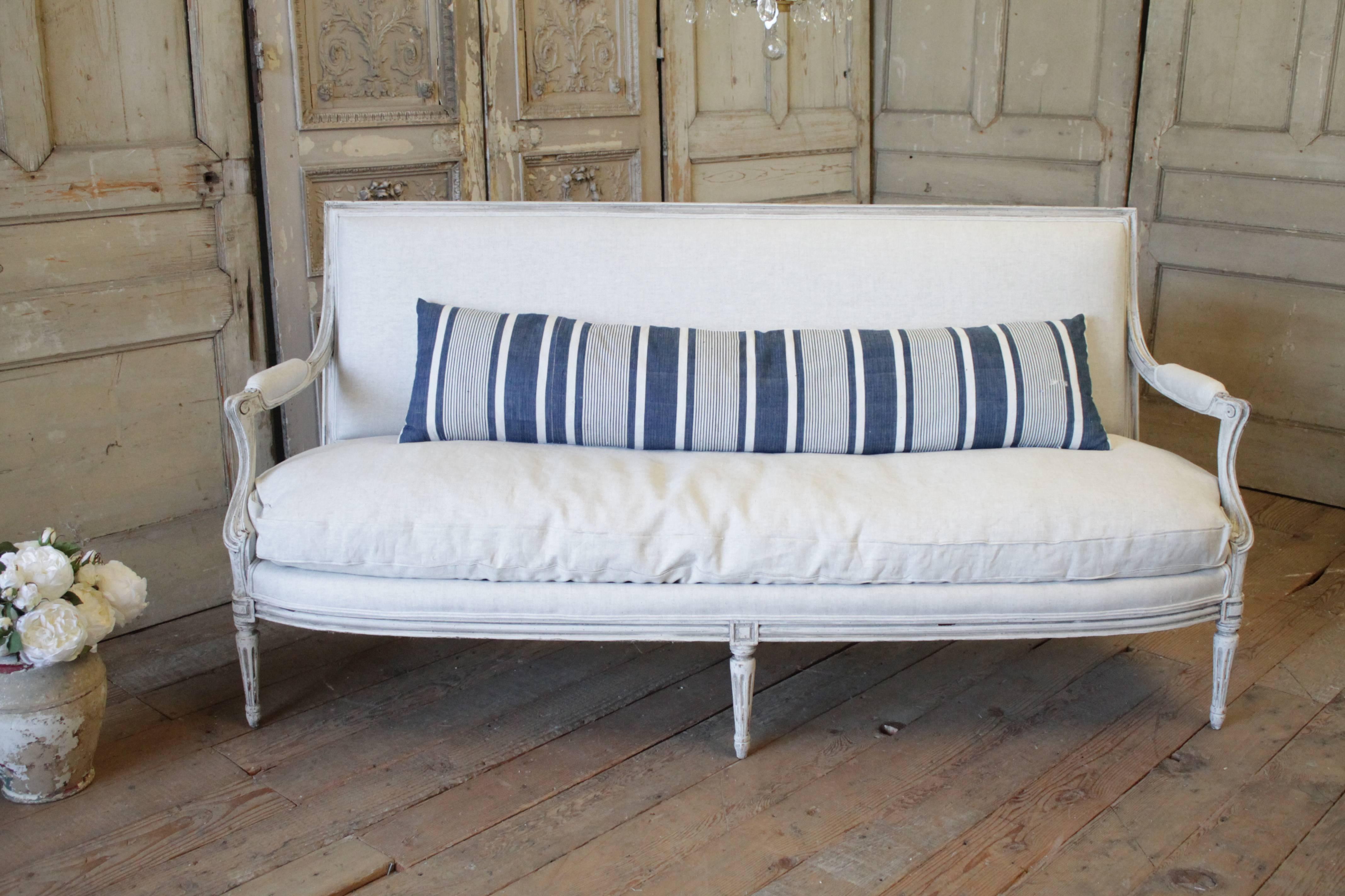Vintage ticking stripe circa 1940 in indigo blue and white. The backside is finished in a vintage French metis white linen and zipper closure. Front and back material are from France and were custom-made in our workroom. A custom down feather pillow