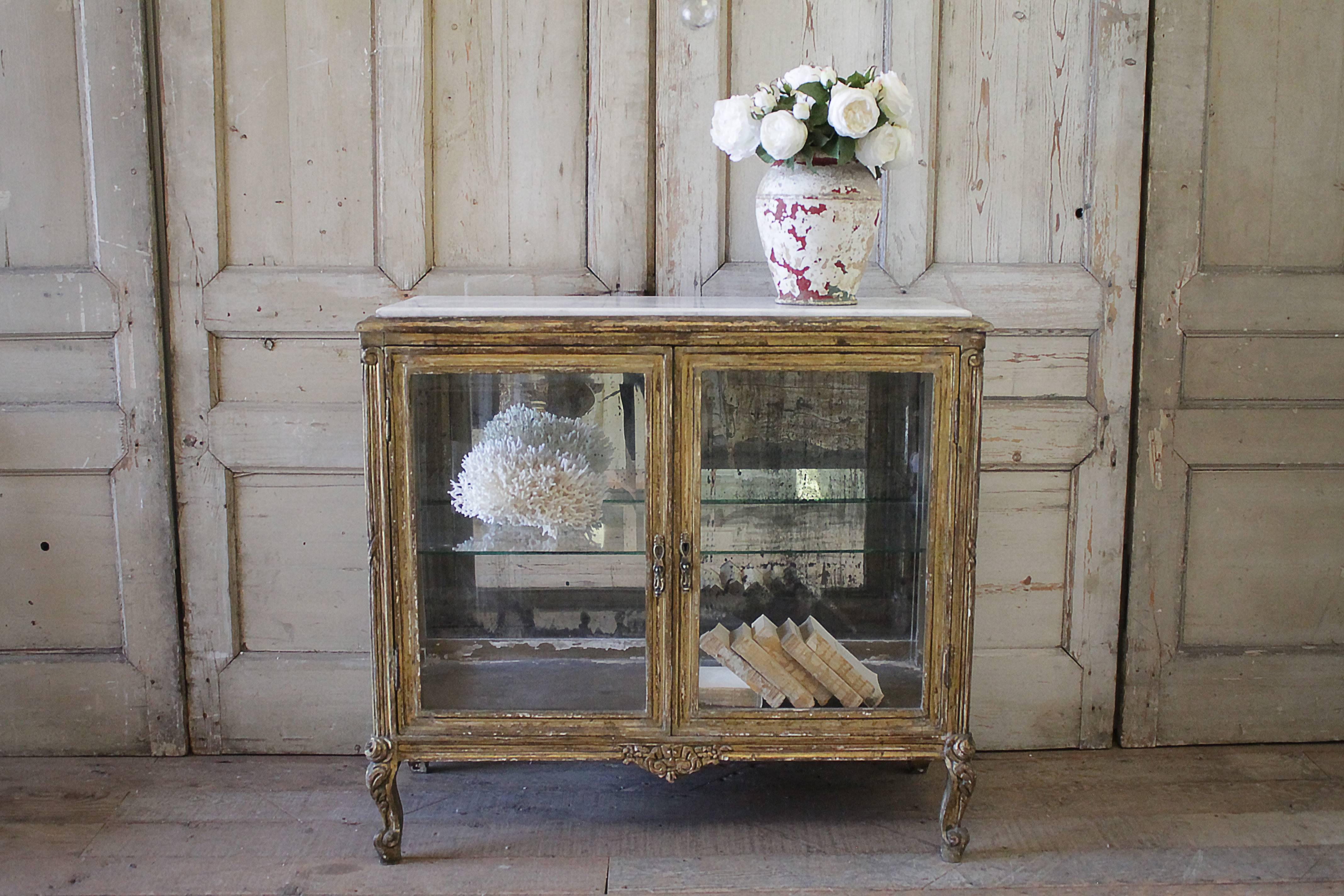 Beautiful French Louis XV Style display cabinet with white marble top. The inside has one glass shelf, and original antique mirror back. The glass on the fronts and sides are all original and have a wavy finish. Curved legs with rosette carved tops.