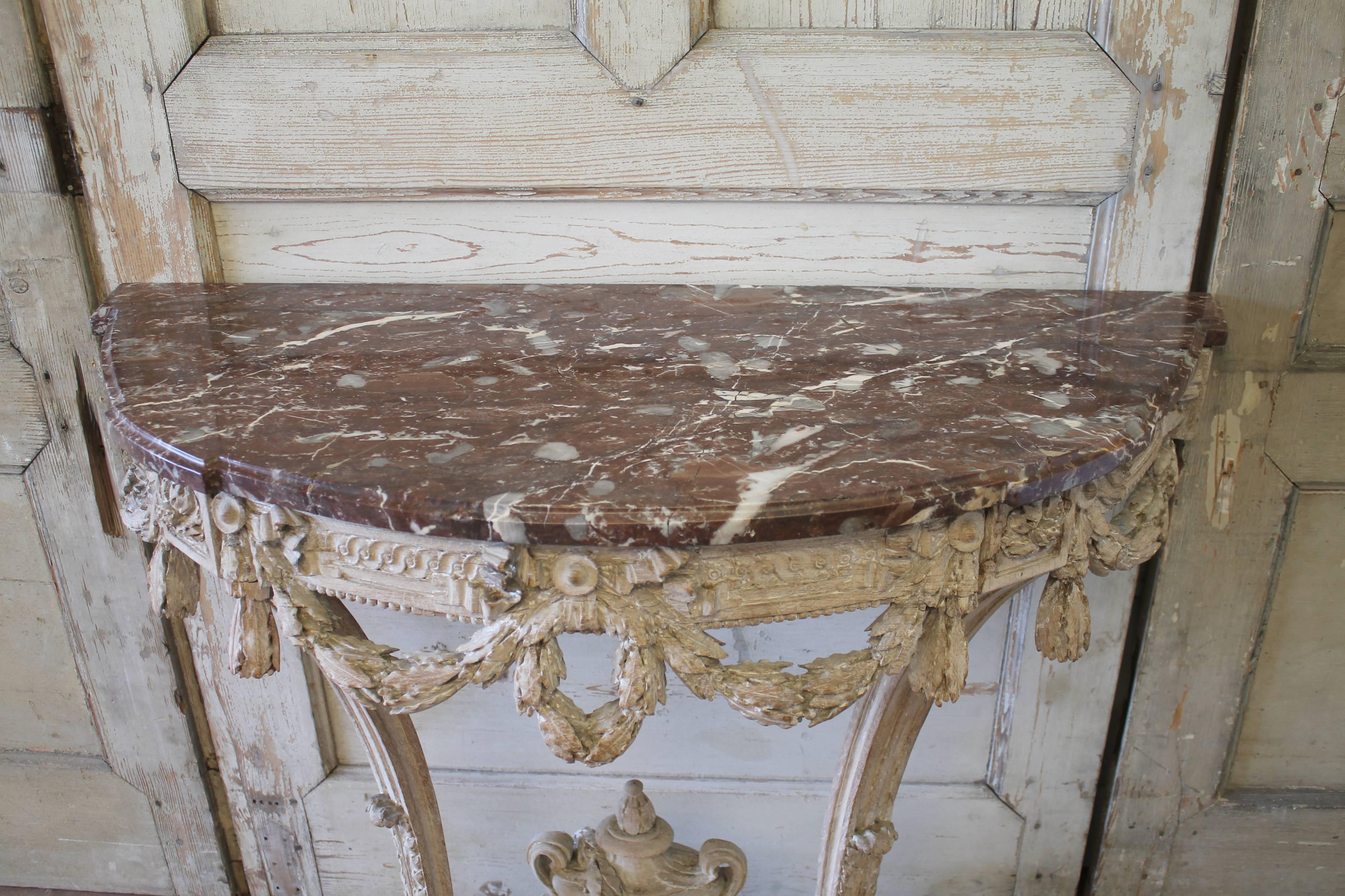 Lovely hand-carved oak console table with marble top. A carved leaf swag decoration surrounds the sides and front. A large carved urn with trailing laurel leaf vine wraps around and over the top of the urn. Console is ready to be attached to the