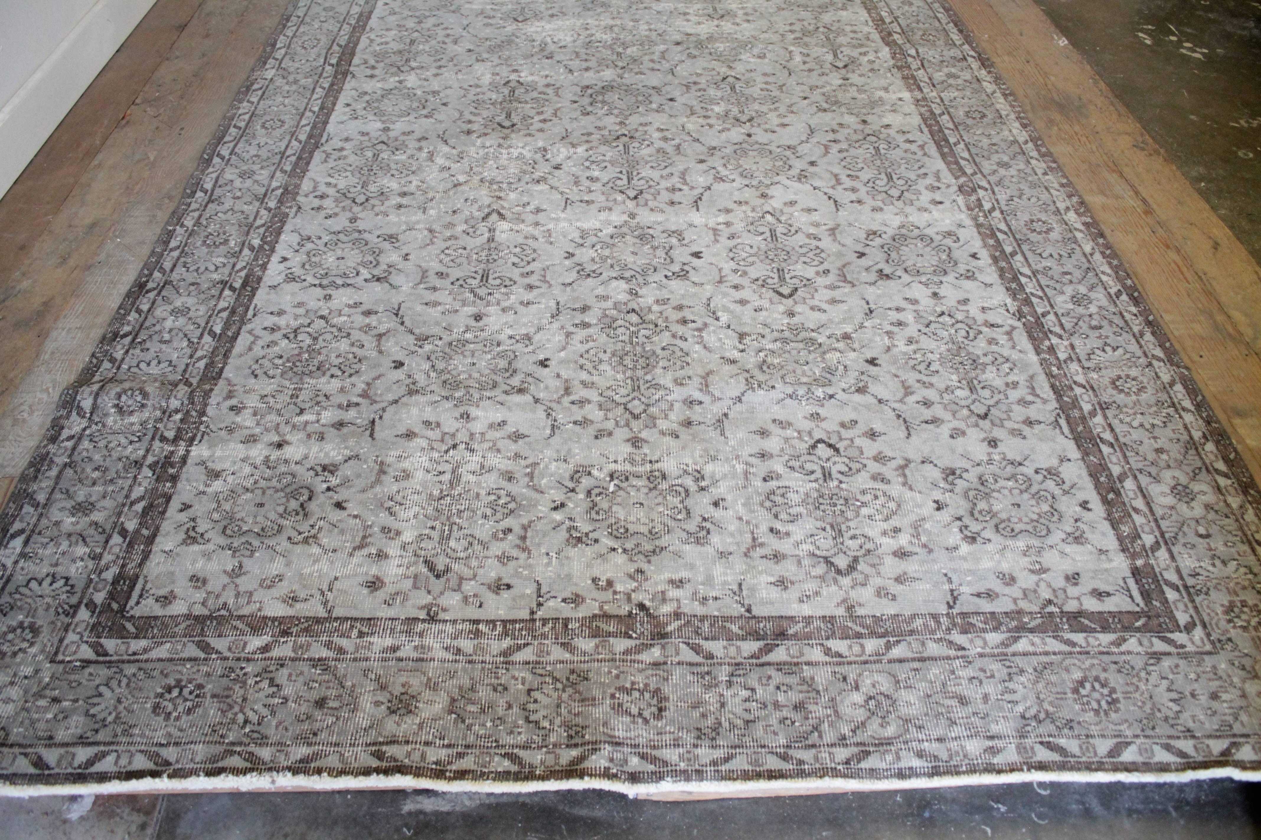 Lovely hand-knotted Turkish rug is pale grey blue color and faded browns. Beautiful scroll patterns, and perfectly faded throughout. Measures: 77