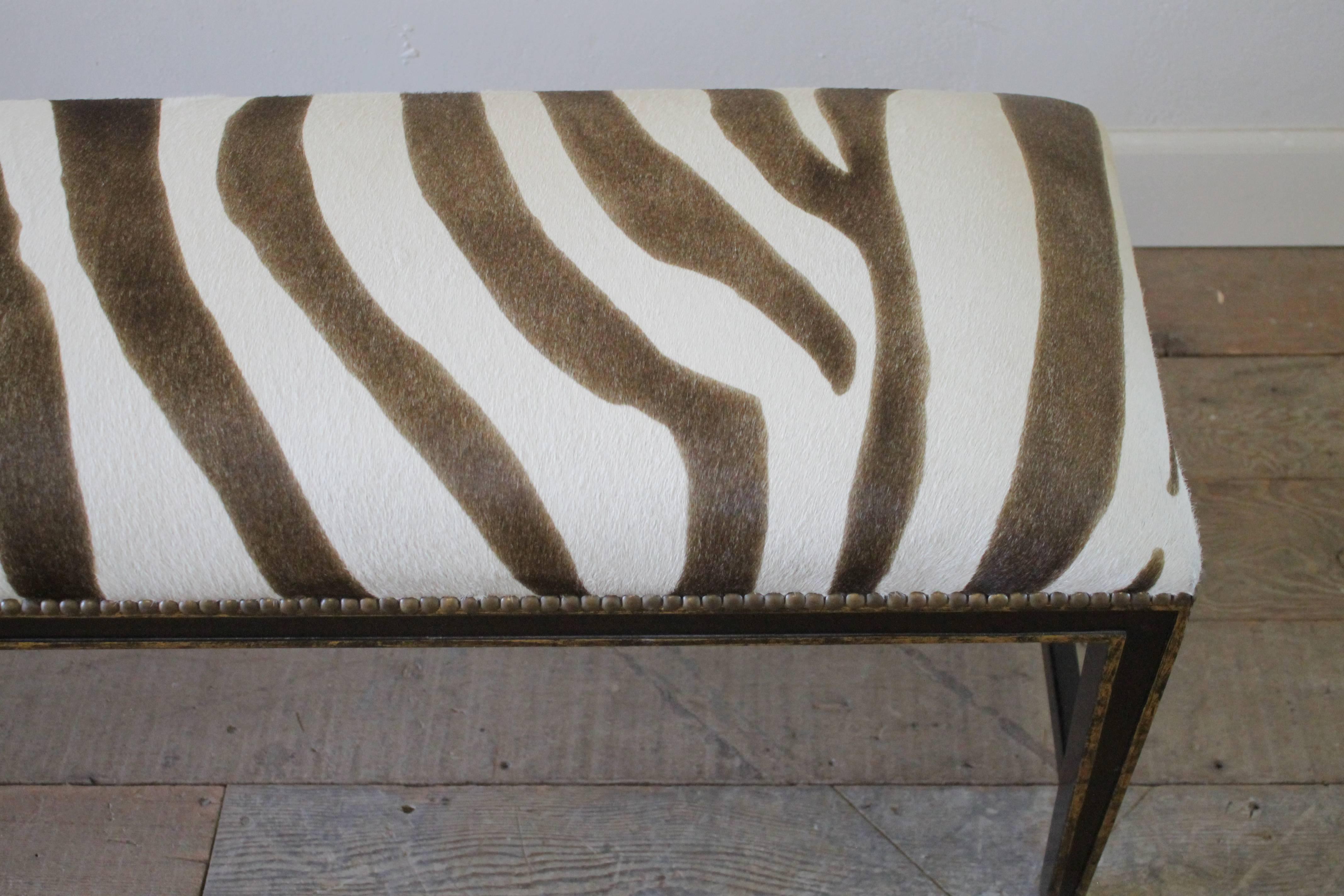 A custom-made bench with faux zebra finished with a nailhead trim. The base is a dark espresso finish with faded gold edges.
Measures: 48 x 16 x 19 H.
 